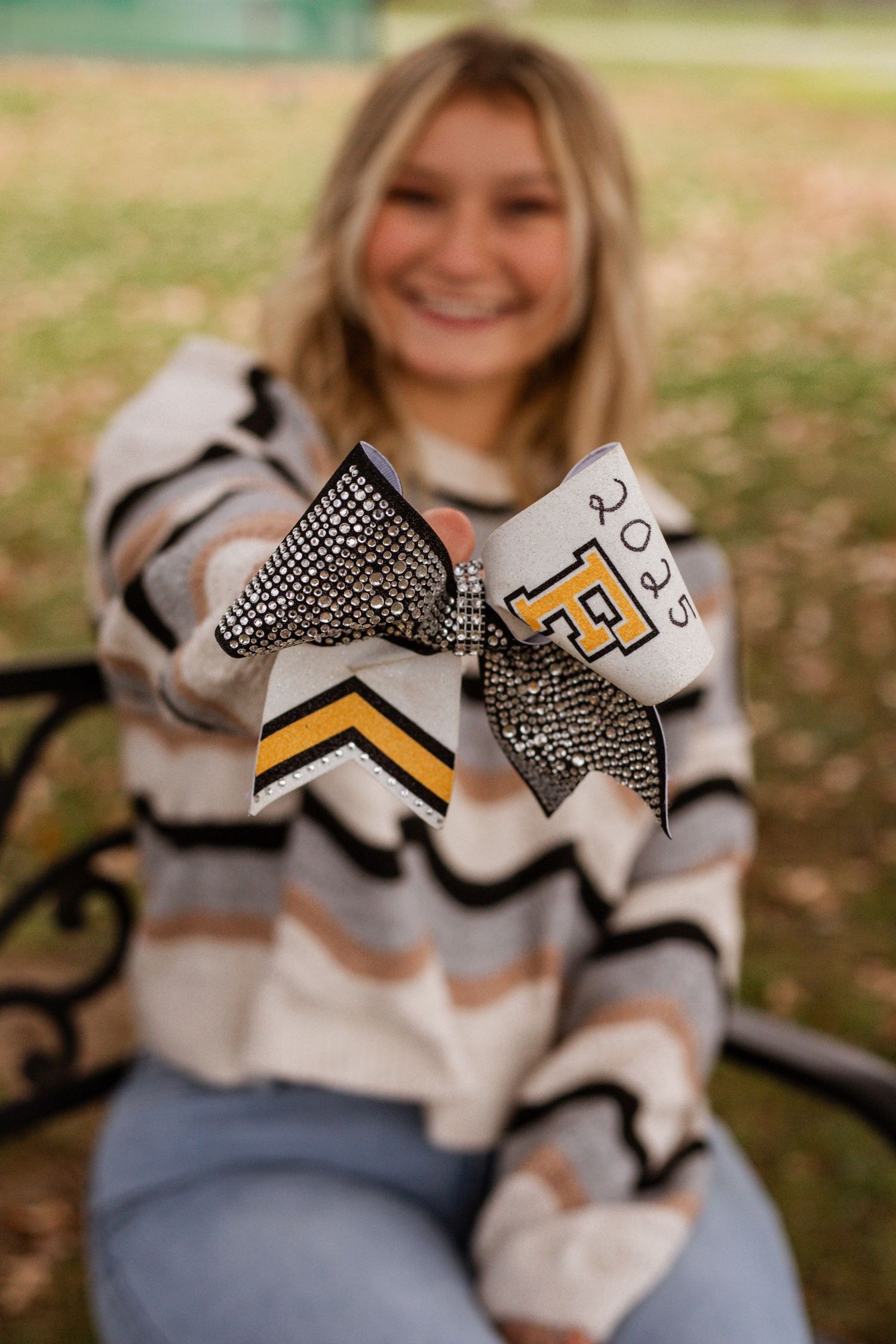 Close-up shots of a chevron patterned sweater with decorative bows and cheerleading accessories.