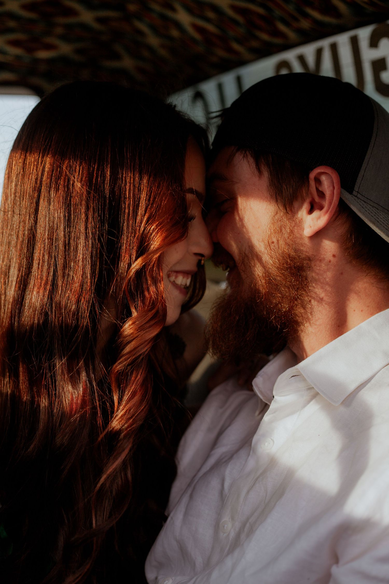 Intimate close-up portrait of a couple in white clothing sharing a tender moment.