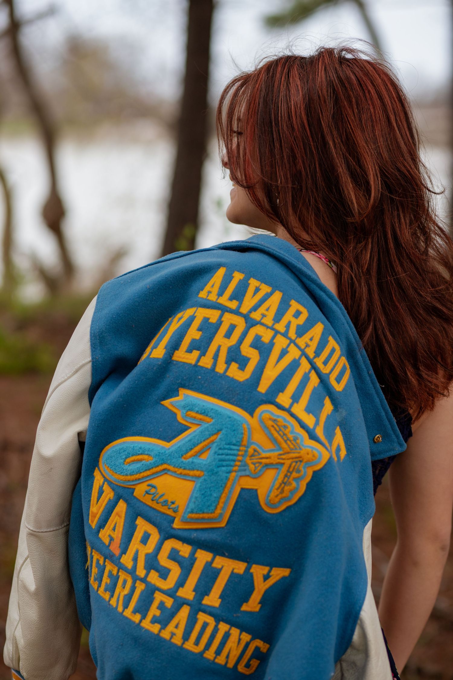 Close-up of blue and gold varsity cheerleading letterman jacket details.