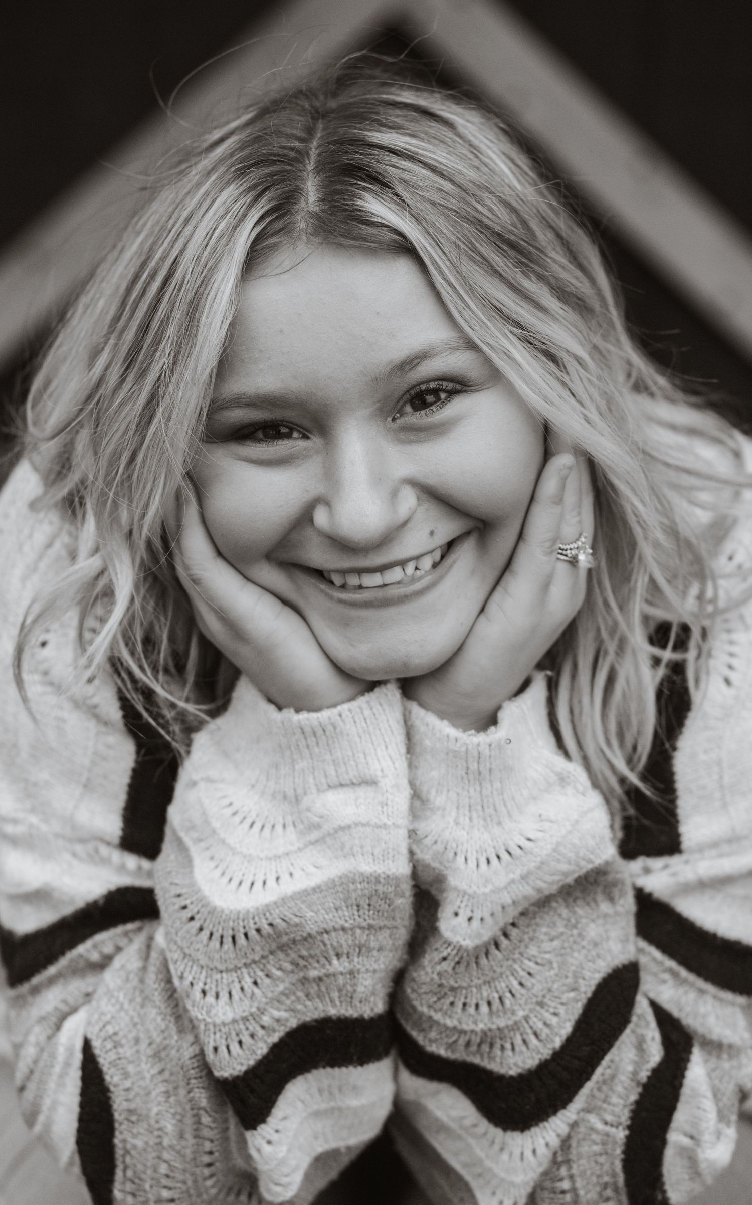 Black and white portrait series showing joyful expressions in cozy sweater.