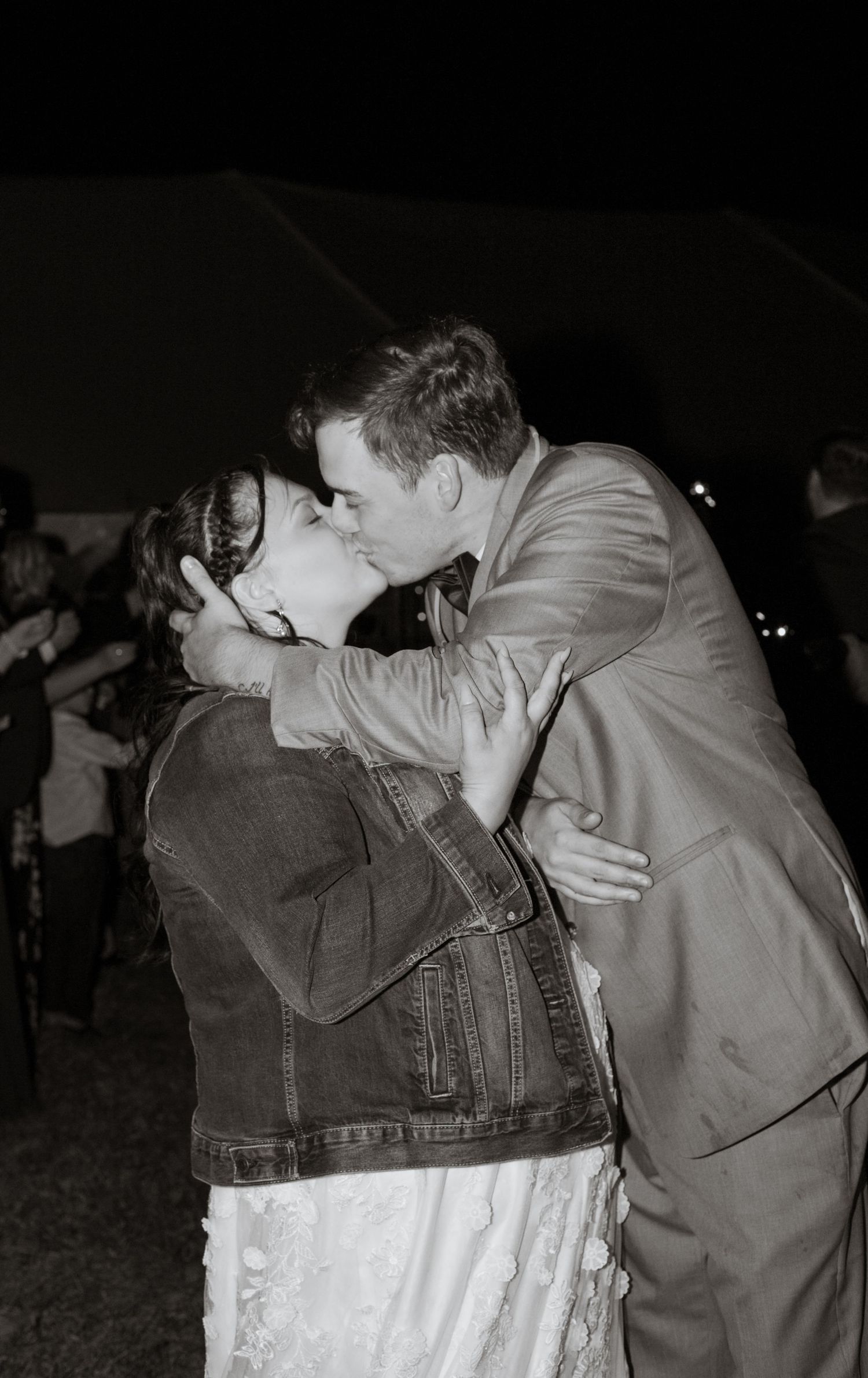 Romantic black and white photo of couple sharing intimate moment at wedding reception.