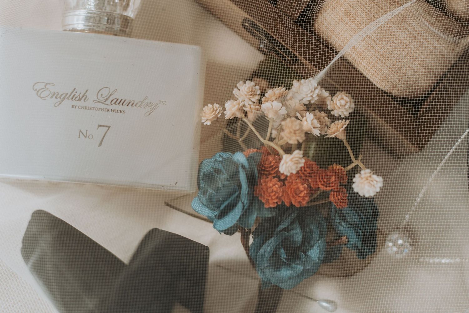 Wedding stationery and floral decorations arranged on neutral background.