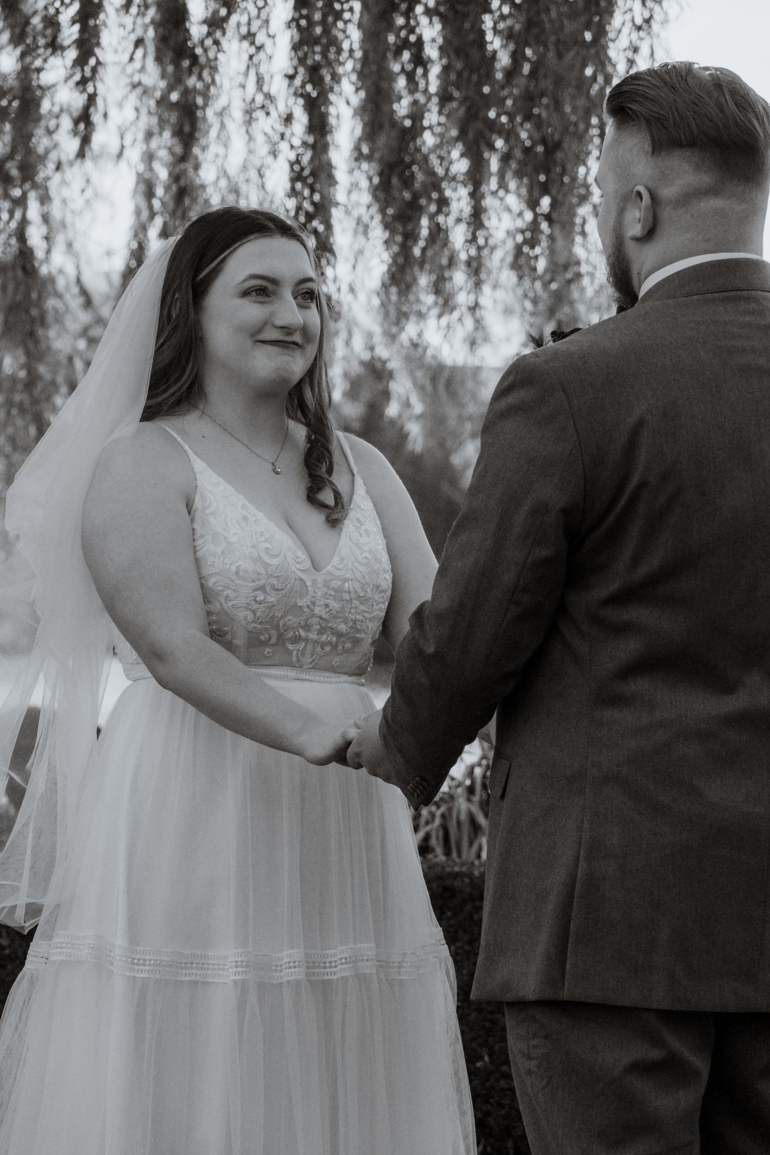 Intimate wedding ceremony moments captured under a weeping willow tree.