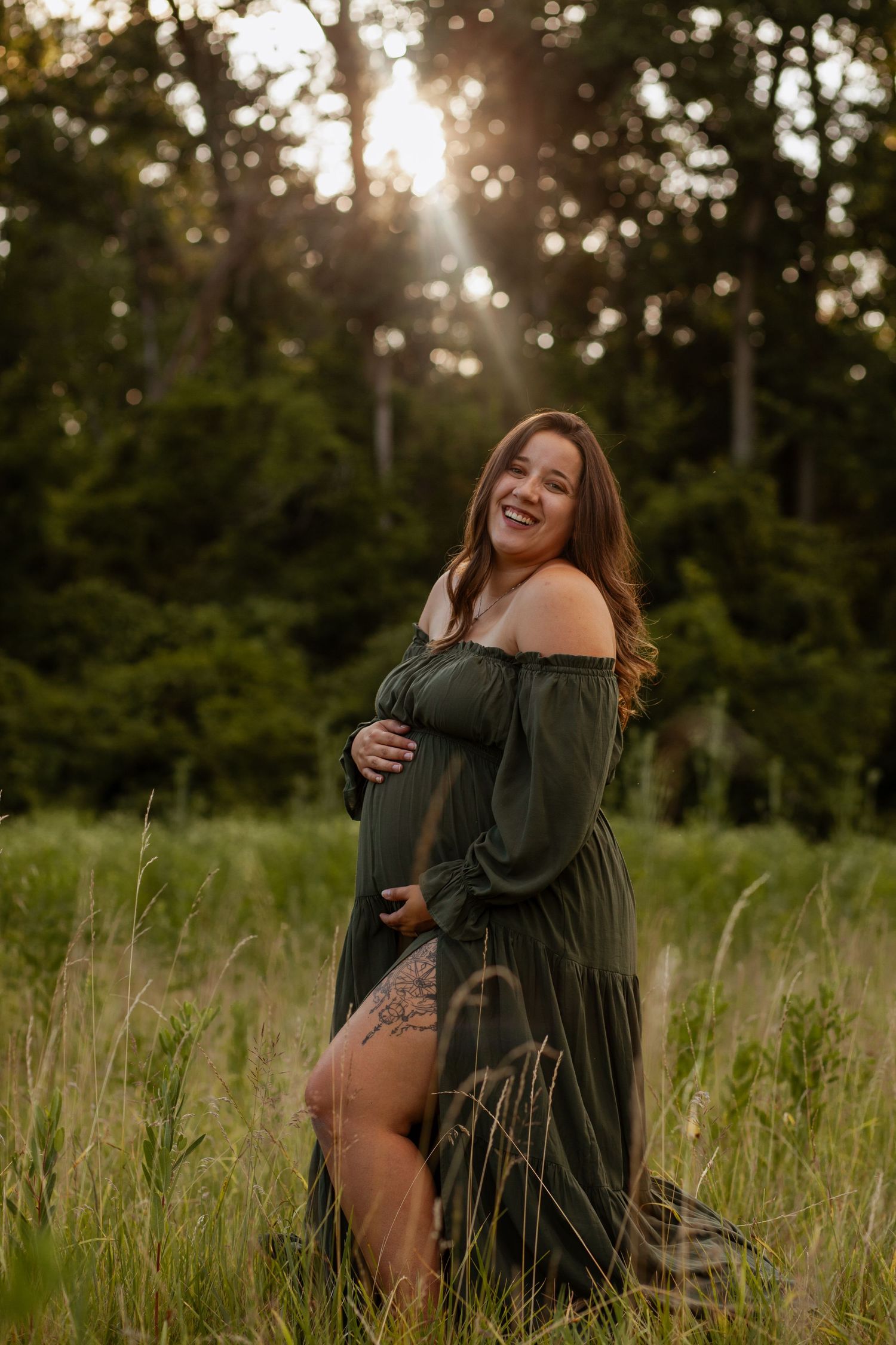 Joyful couple laughing and hugging in a sun-drenched field during golden hour.