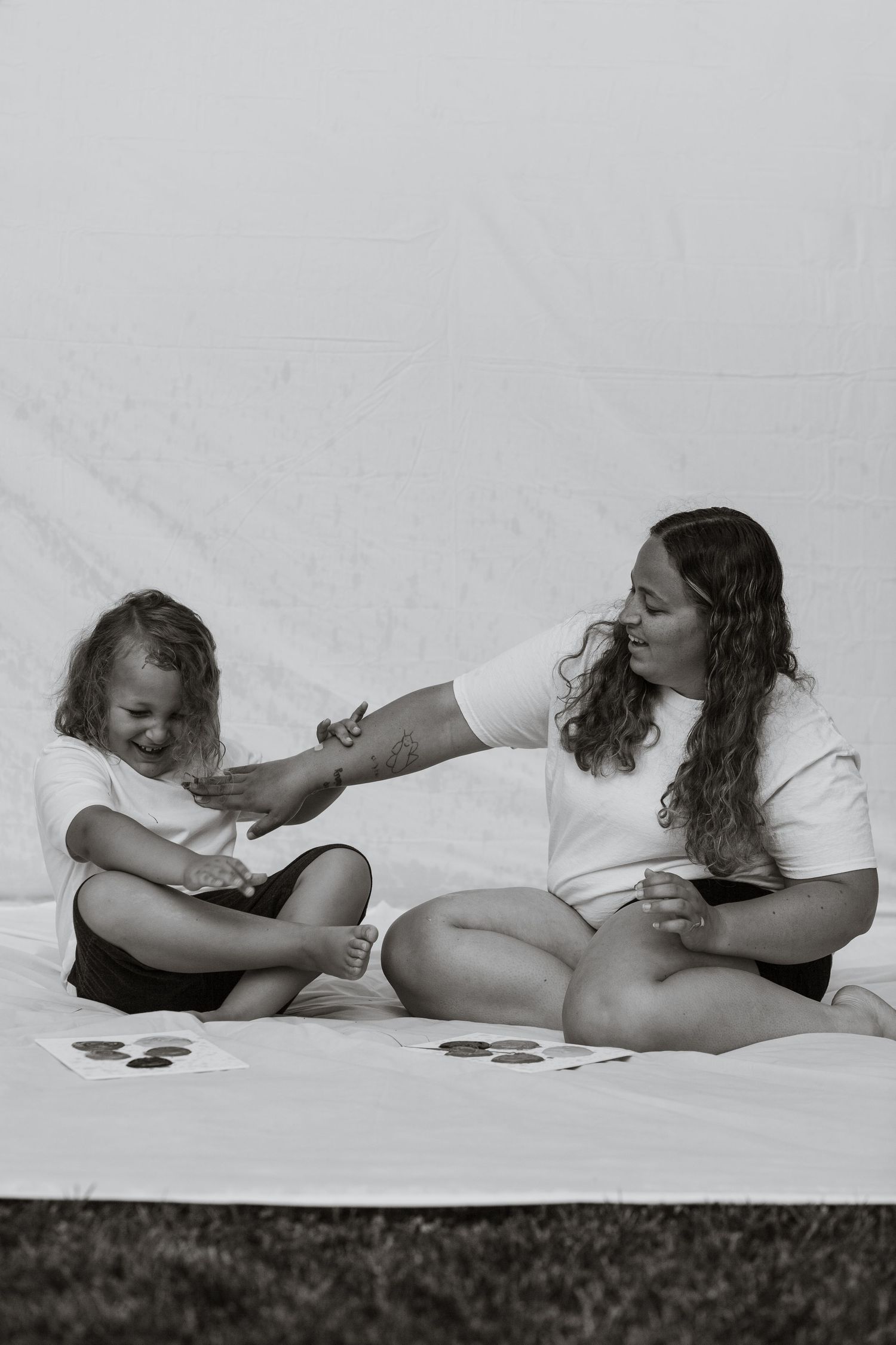 Artistic black and white maternity photoshoot on white backdrop.
