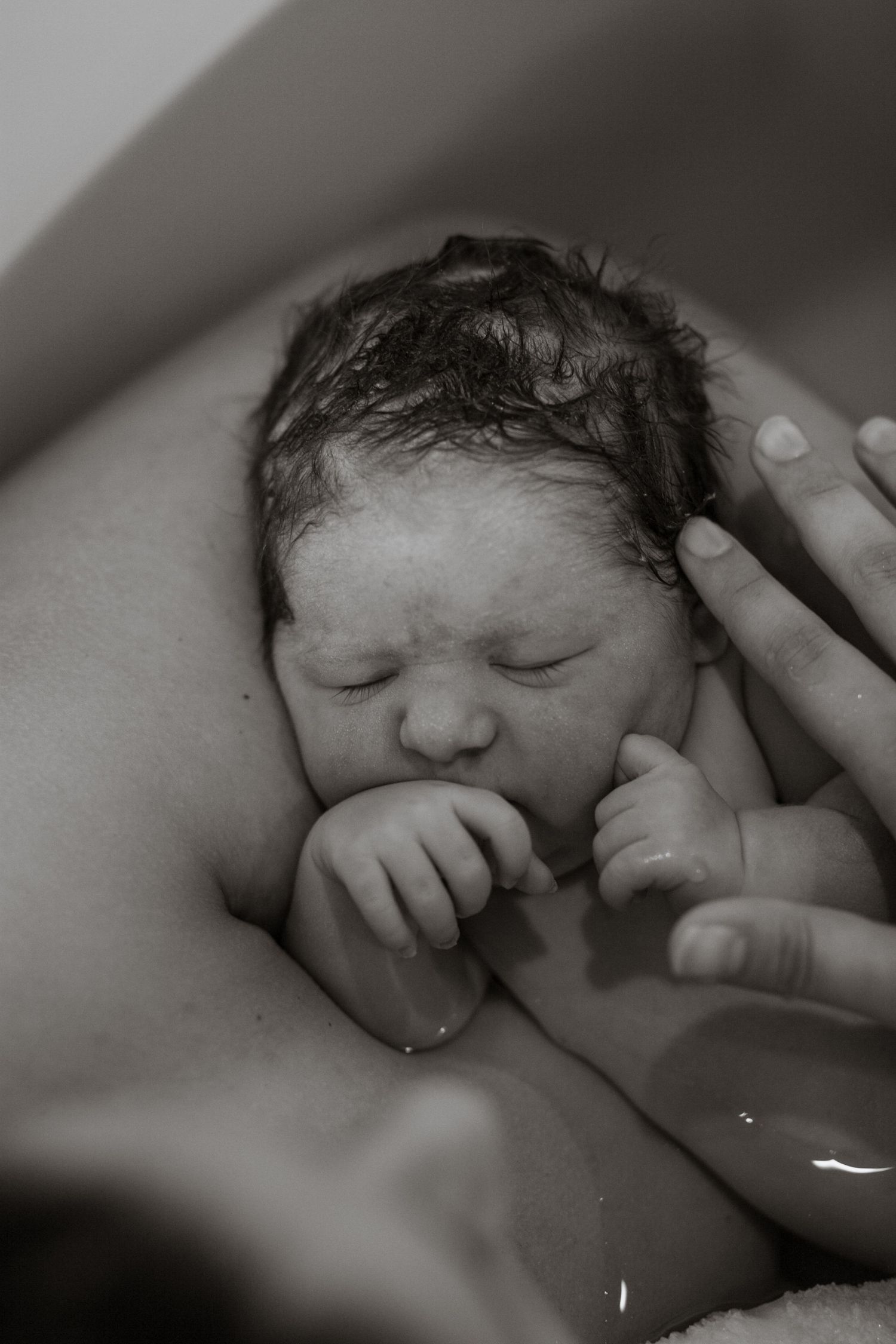 Black and white photos capturing a newborn's first moments after birth.