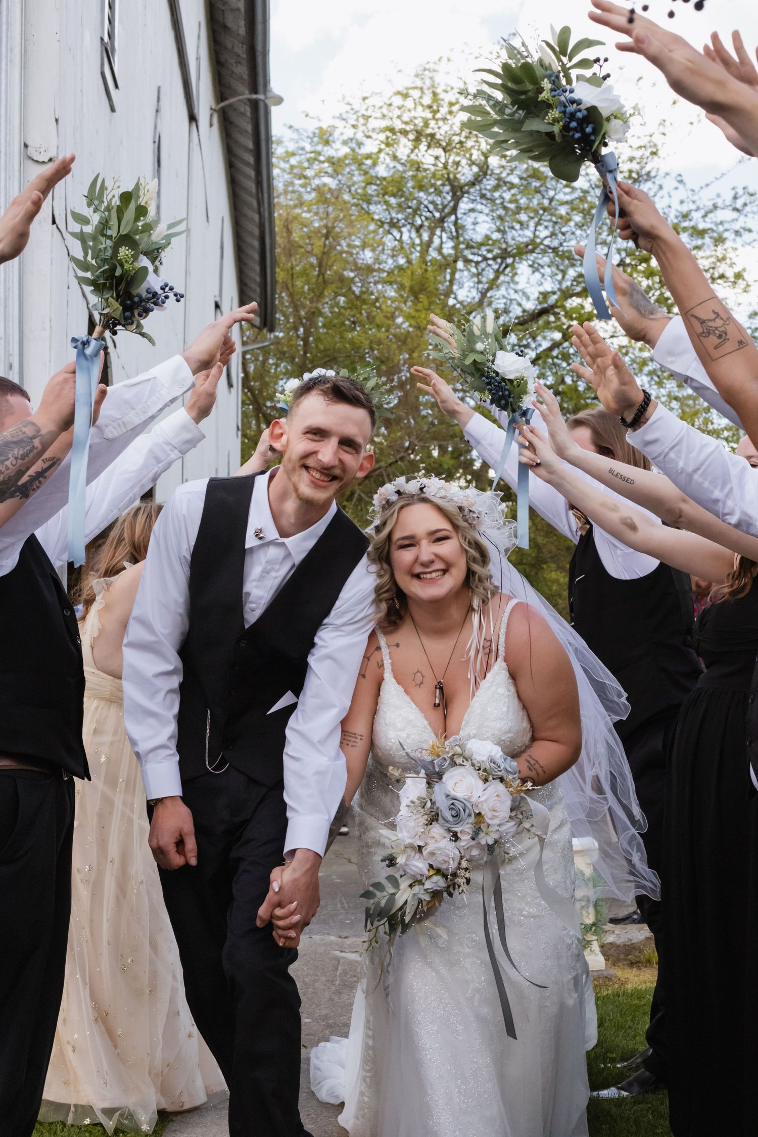 A joyful wedding celebration with guests throwing confetti outside.