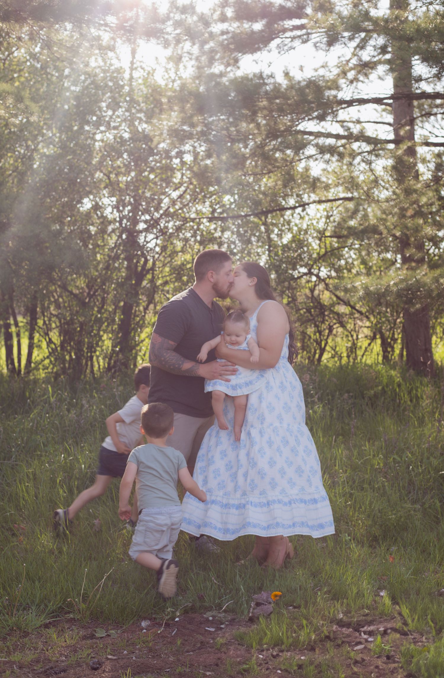 Family photoshoot sequence in a sunlit field with natural, candid interactions.