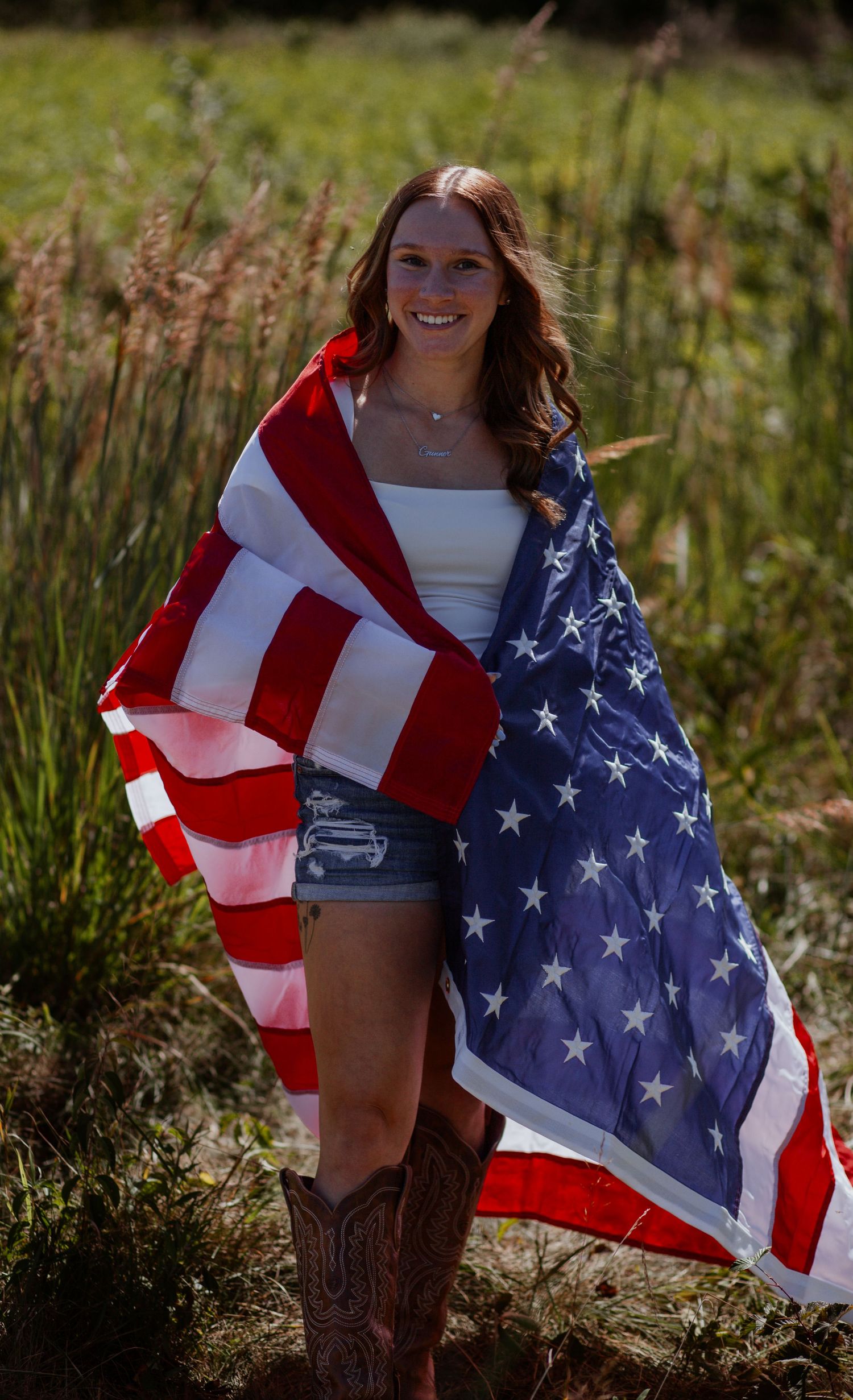 American flag draped in outdoor field setting with brown cowboy boots.