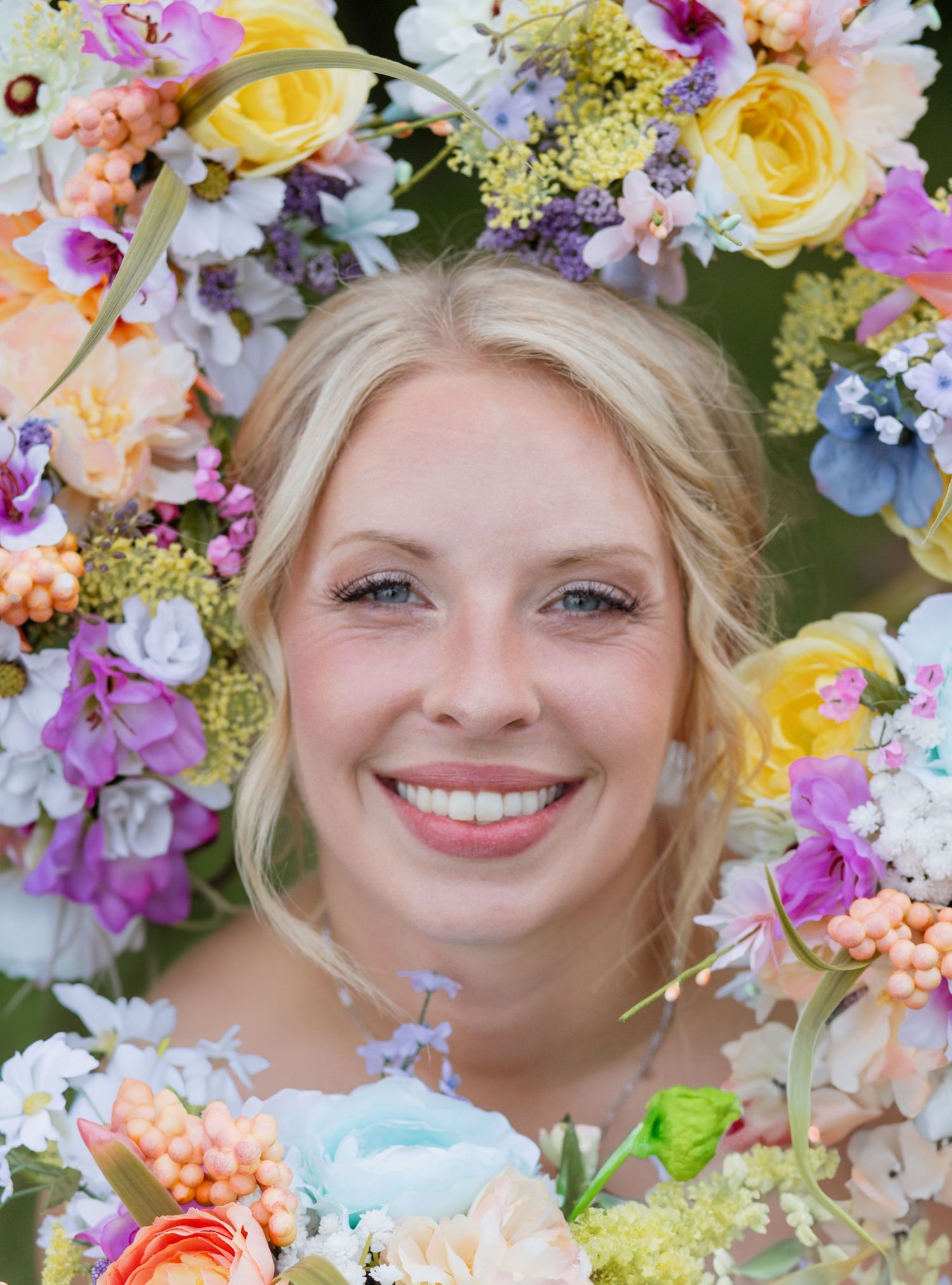 Colorful floral frame surrounds a bright wedding portrait.
