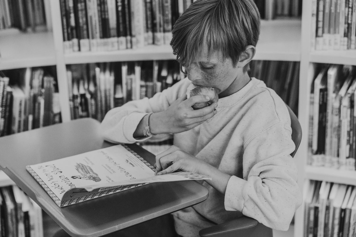 Boy reading a book in a Calgary family photography session at the Central Calgary Public Library.