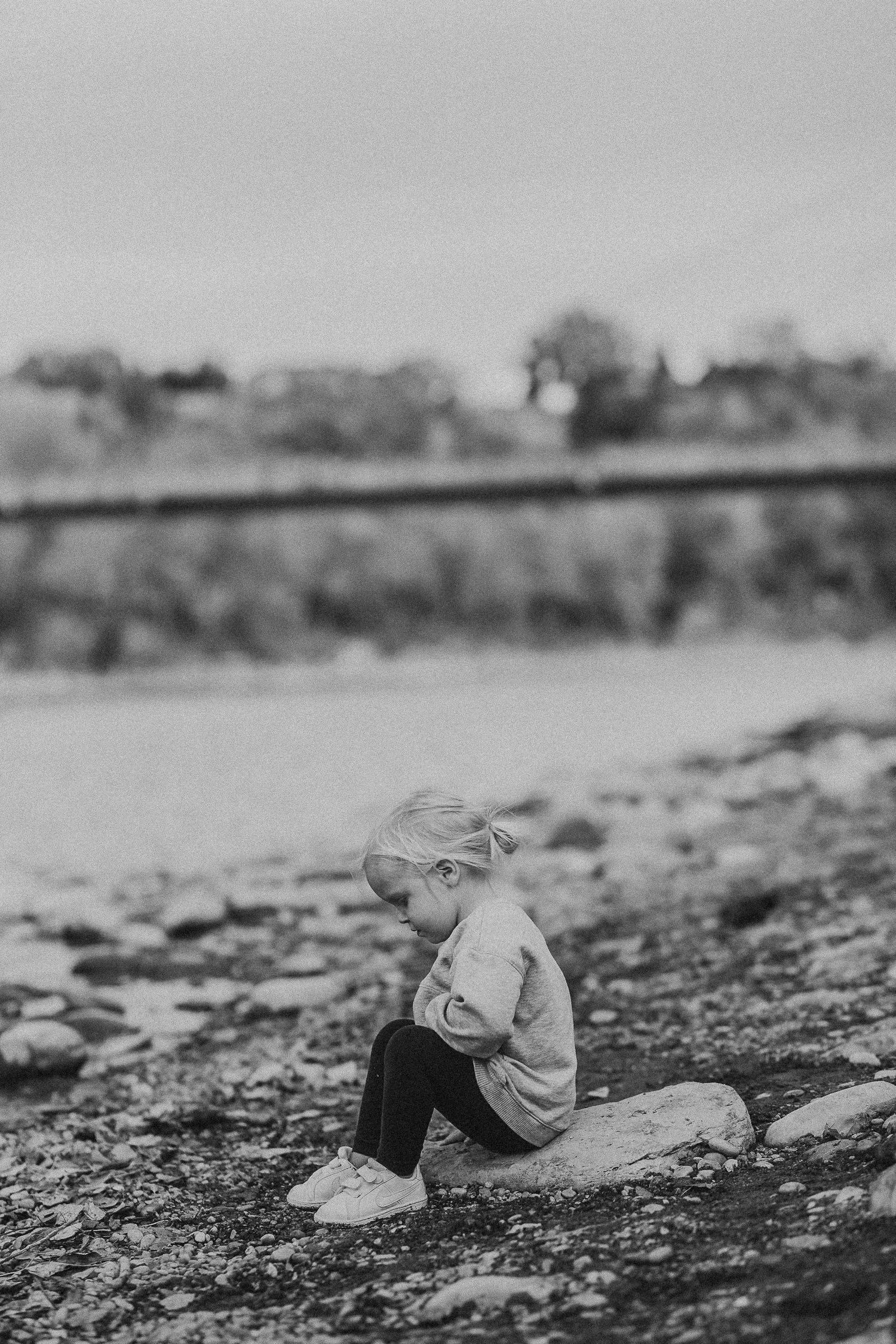 Toddler girl playing in the river in a documentary style Calgary family photography session in Prince's Island Park