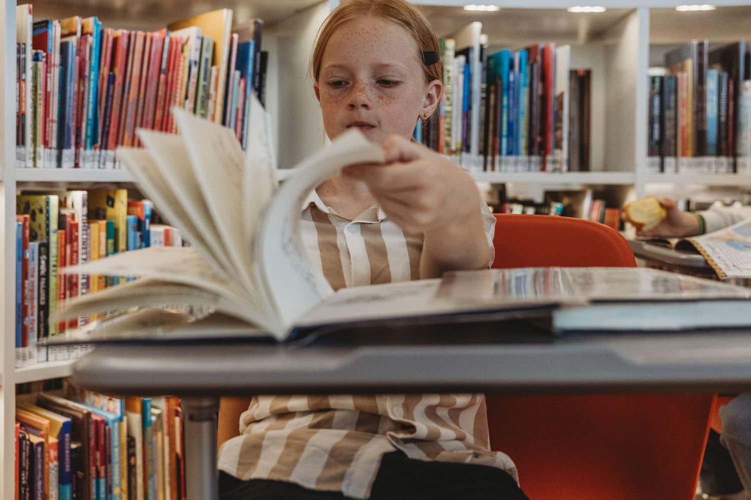 Girl reading a book in a Calgary family photography session at the Central Calgary Public Library.