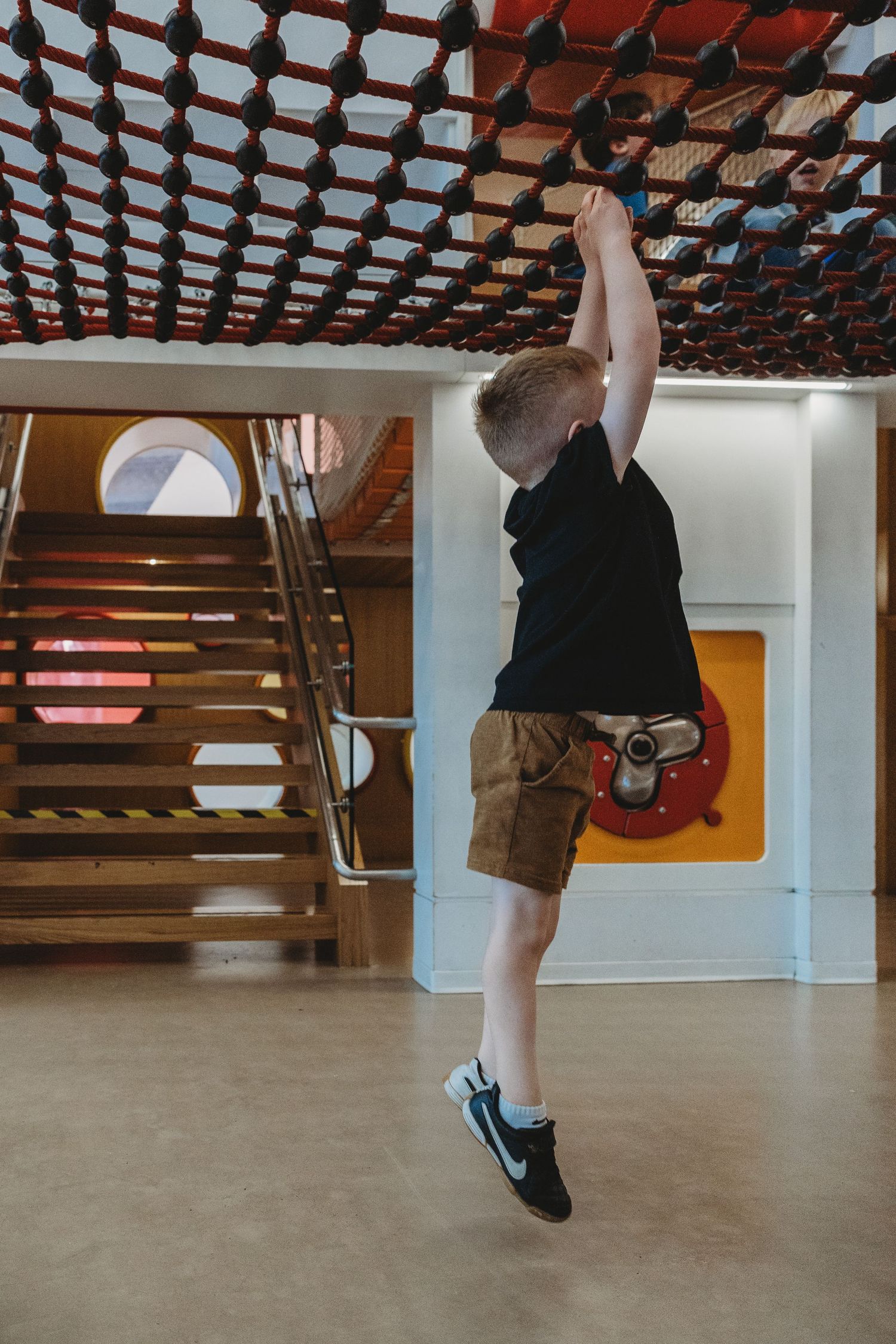 Boy on the play structure in a Calgary family photography session at the Central Calgary Public Library.