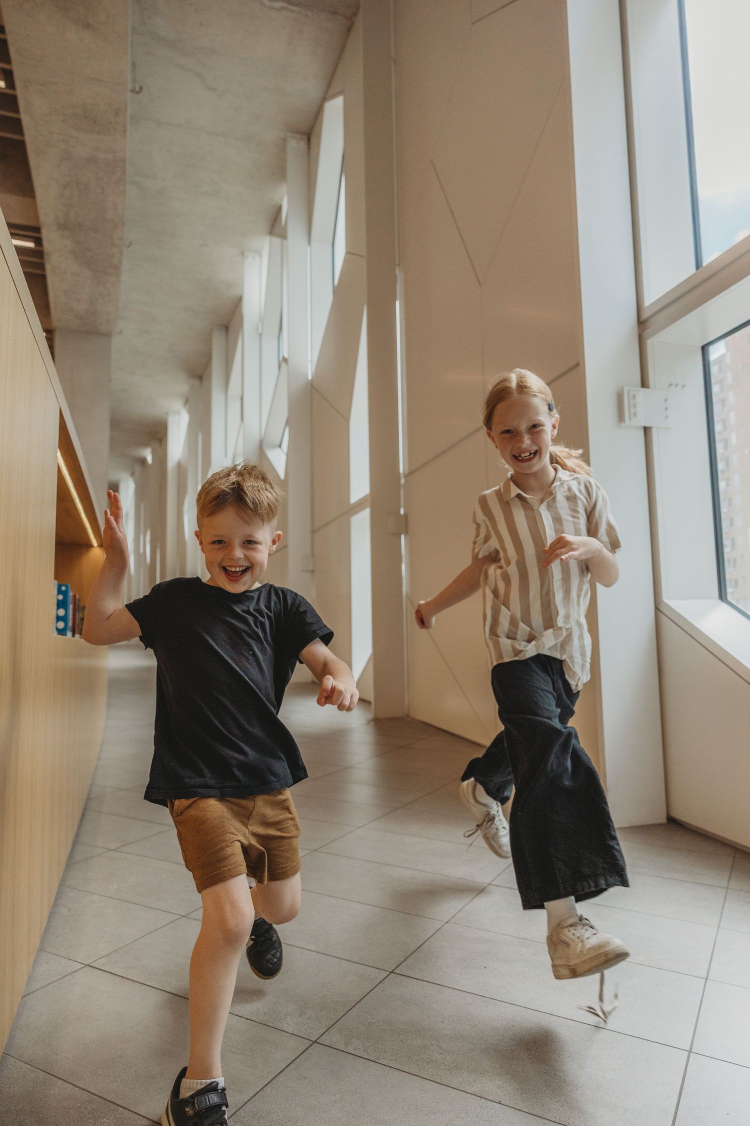 Kids running in a Calgary family photography session at the Central Calgary Public Library.
