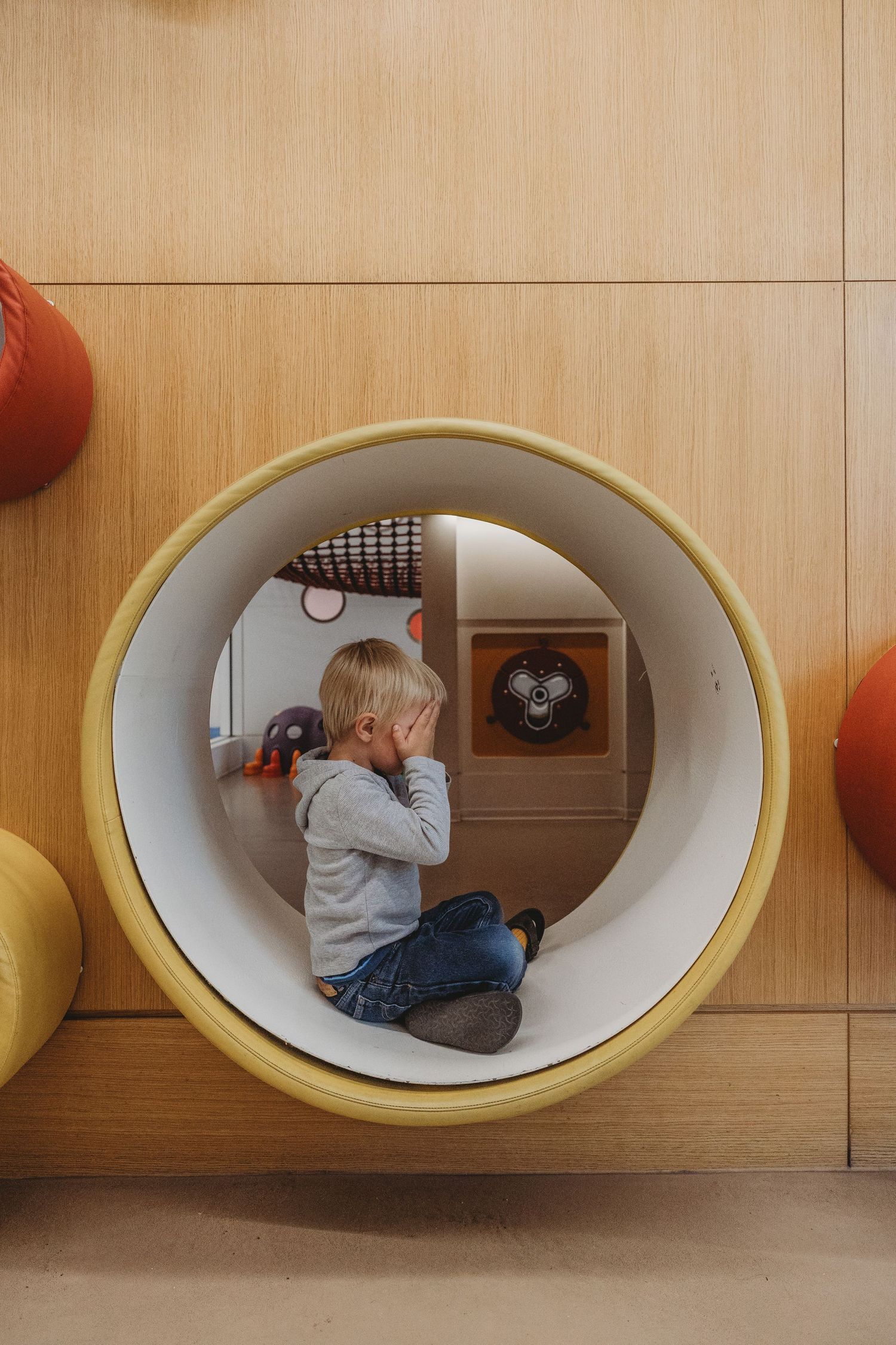 Toddler boy on the play structure in a Calgary family photography session at the Central Calgary Public Library.