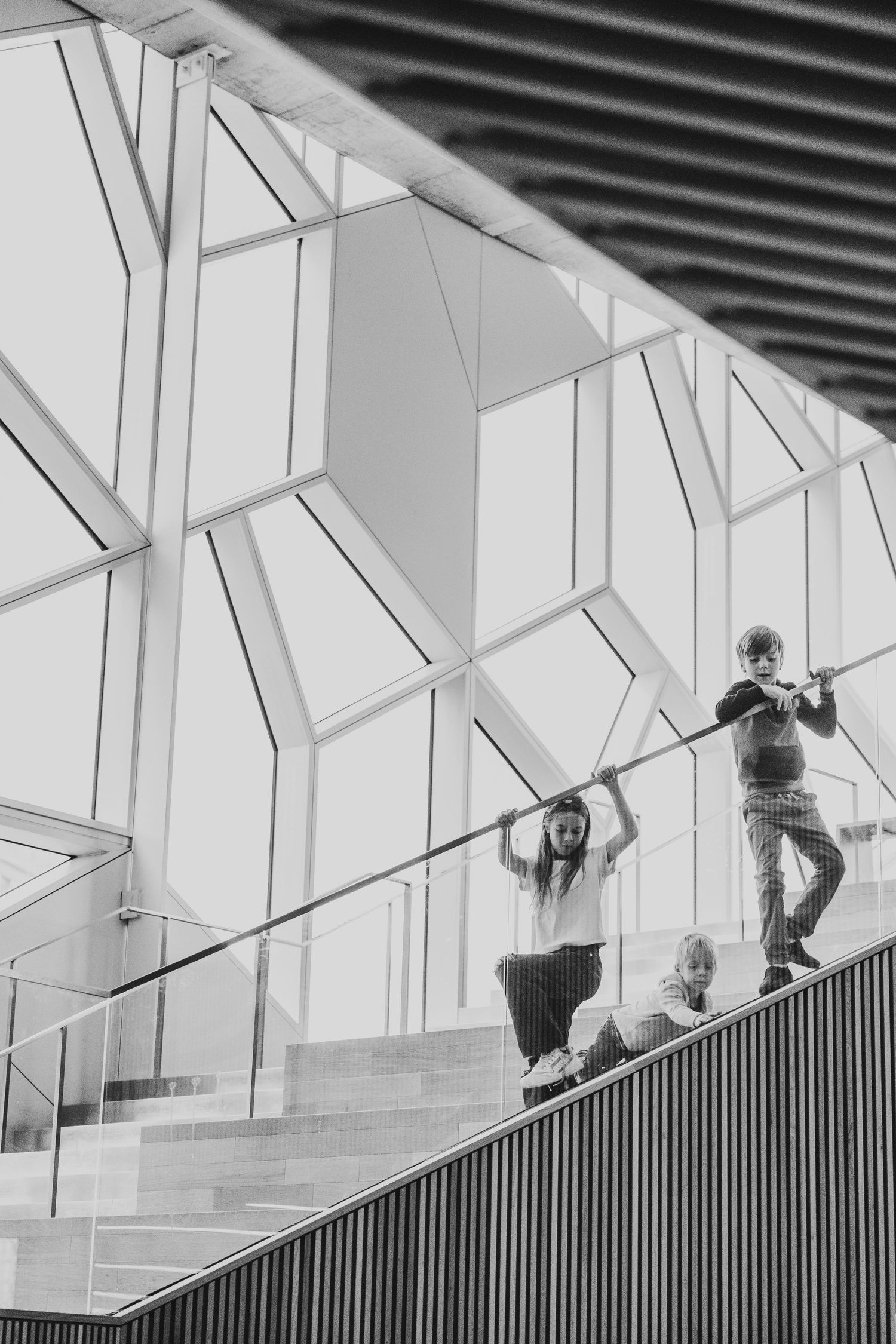 Siblings walking on the stairs in a Calgary family photography session at the Central Calgary Public Library.