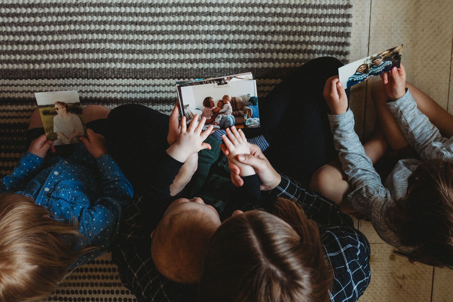 Mom and kids holding an old photography in an in-home Calgary family photography session.