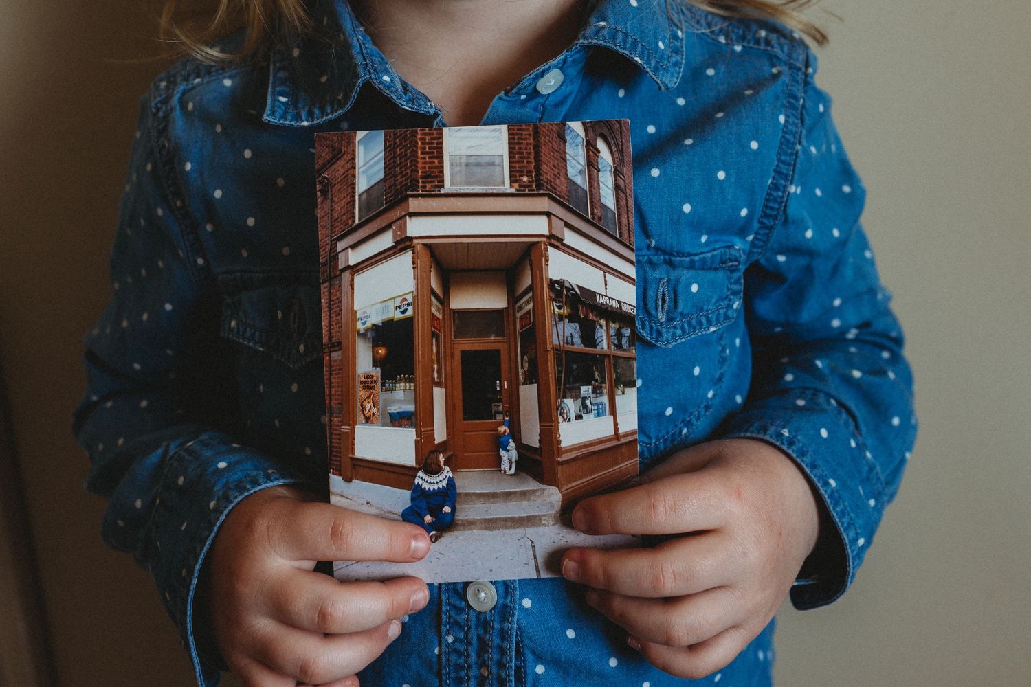 Girl holding an old photography in an in-home Calgary family photography session.