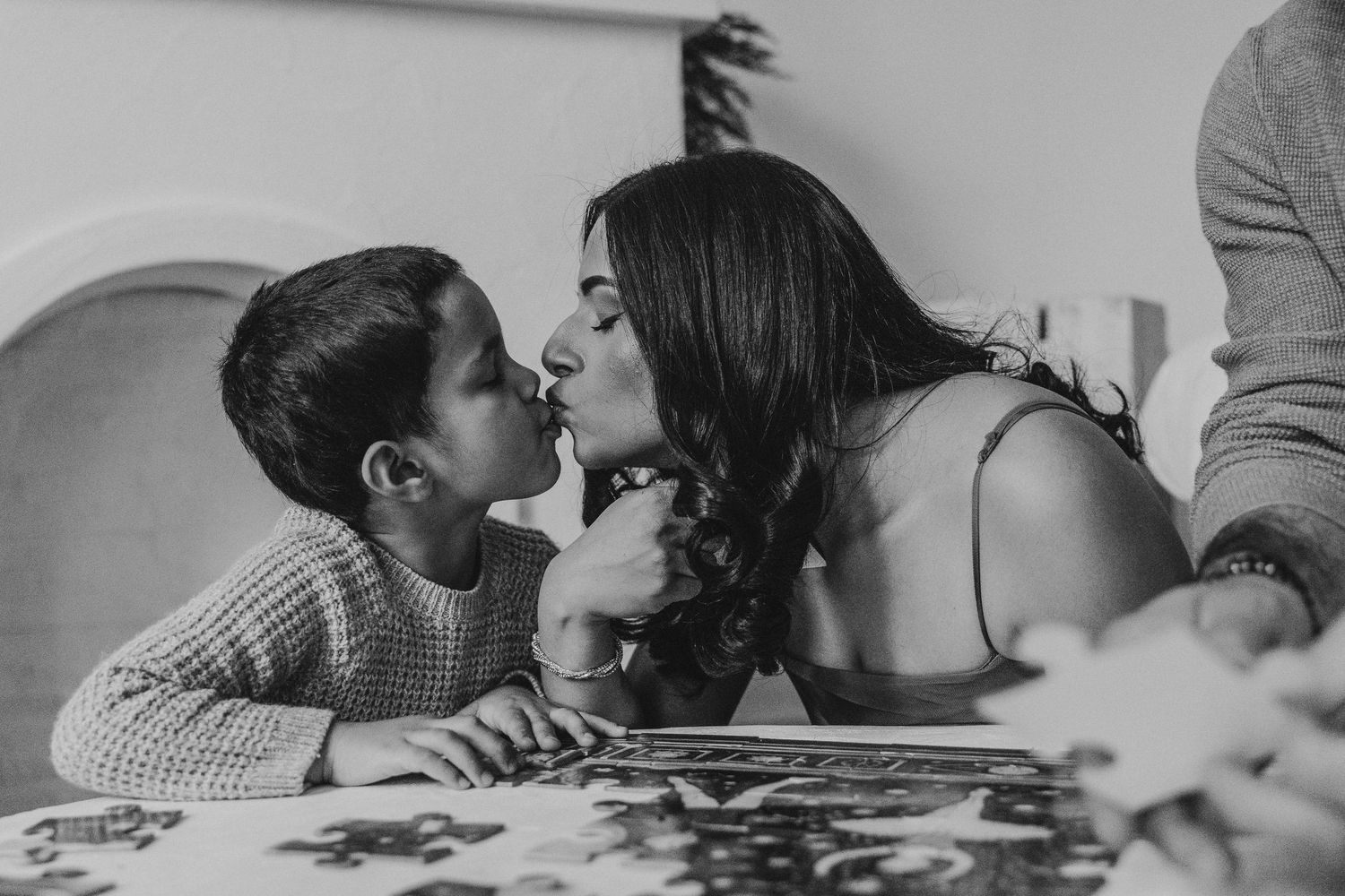 Mother and son playing with a puzzle in a documentary style Calgary family photography session at The Study Studios in downtown Calgary