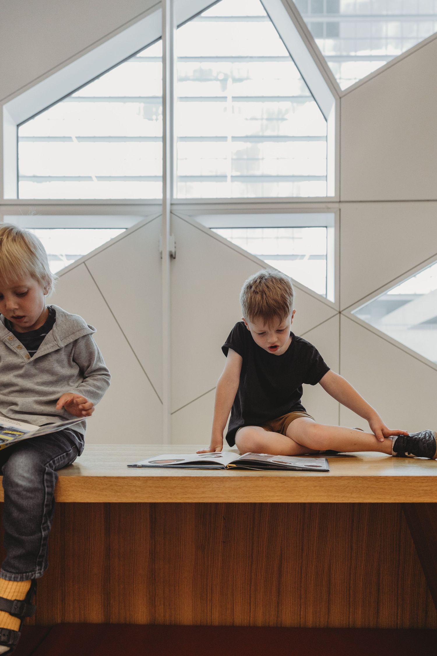 Boy reading a book in a Calgary family photography session at the Central Calgary Public Library.