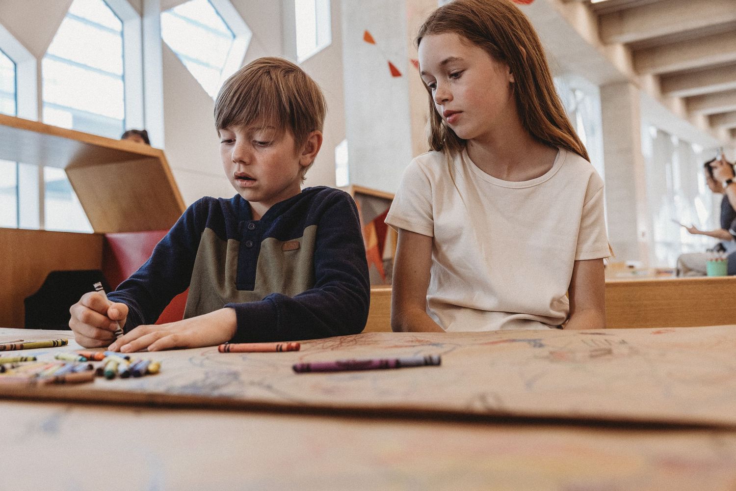Girl and boy drawing in a Calgary family photography session at the Central Calgary Public Library.