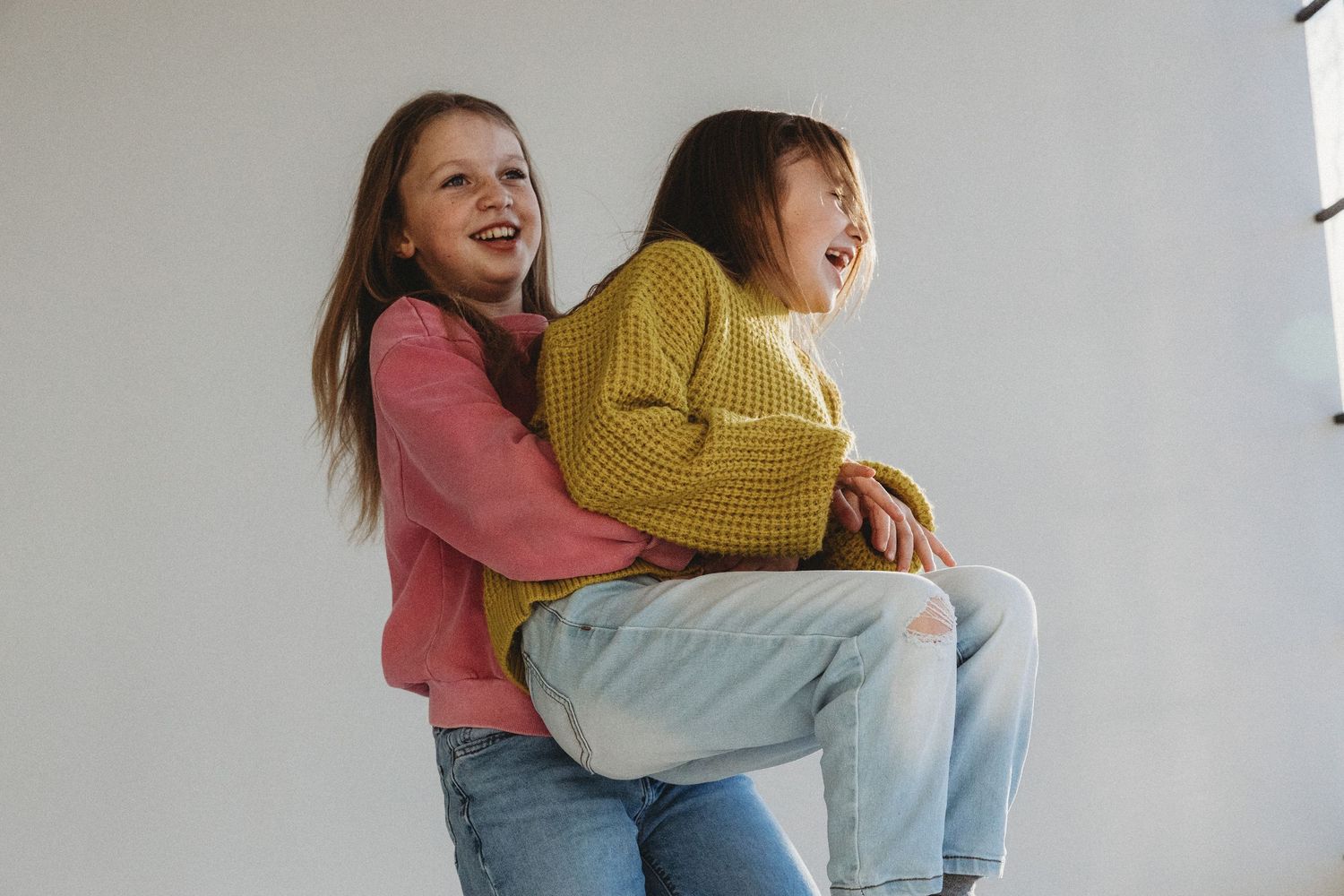 Sisters dancing together during a Calgary Mini Session at Studio Boheme. Calgary family photography.