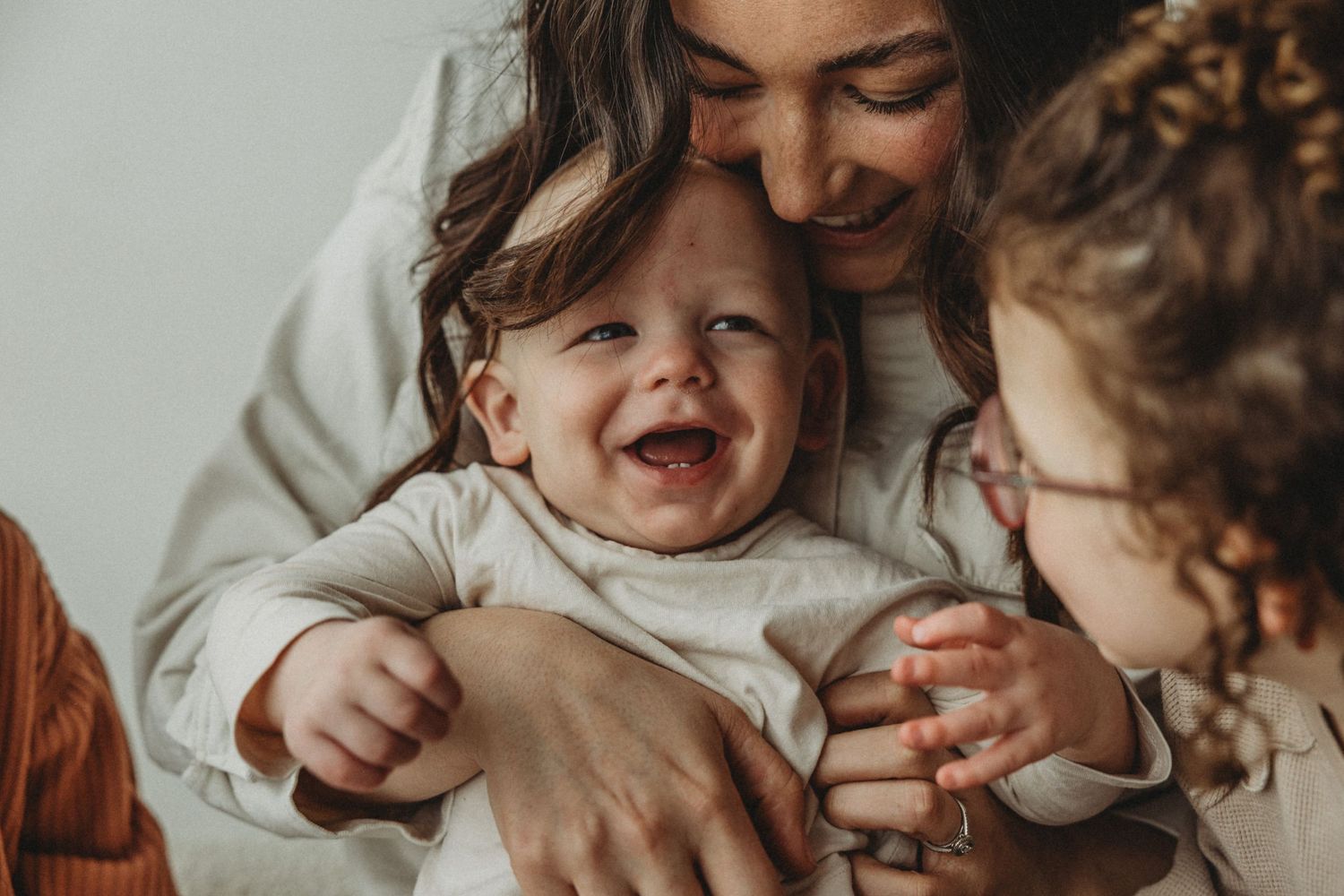 Mother holds smiling baby during Motherhood Mini Sessions at The Gallery Studio with Calgary family photographer