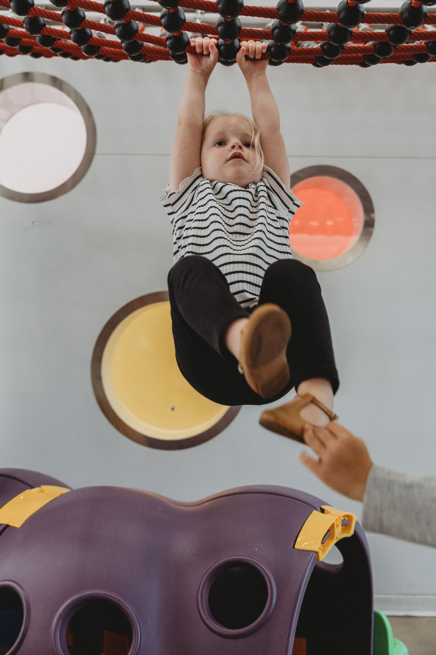 Toddler girl on the play structure in a Calgary family photography session at the Central Calgary Public Library.