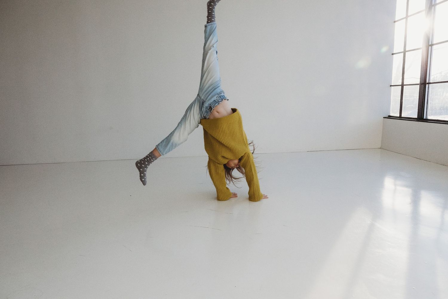 Girl does a cartwheel during a Calgary Mini Session at Studio Boheme. Calgary family photography.