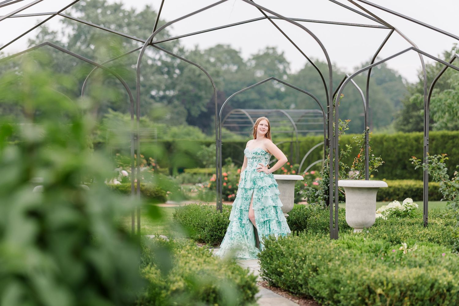 Wide senior portrait of Samantha surrounded by the formal gardens and arbors at Cantigny Park in Wheaton.