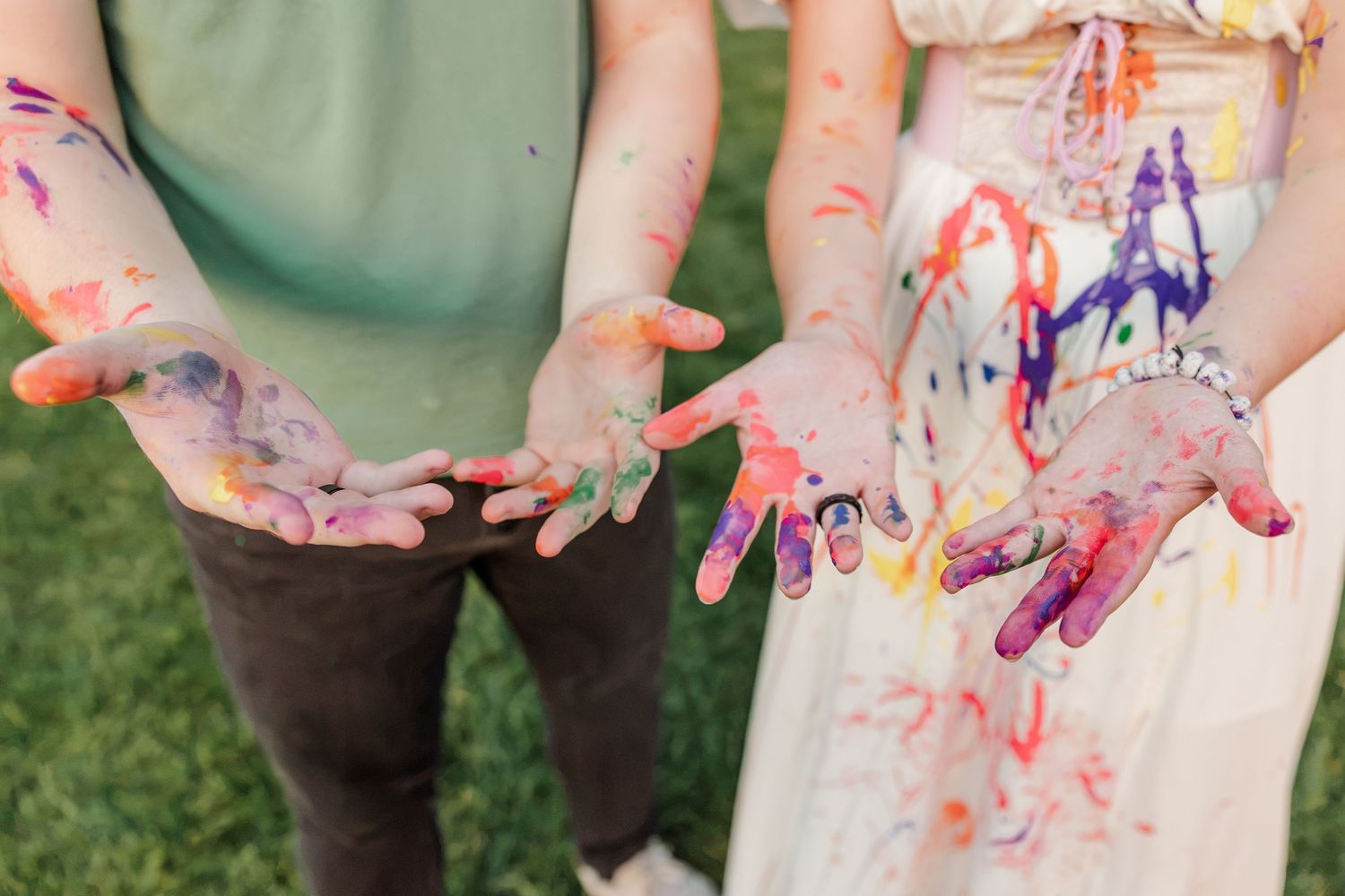 Samantha and Carl show their paint-covered hands after creating colorful art together during her Cantigny Park senior session.