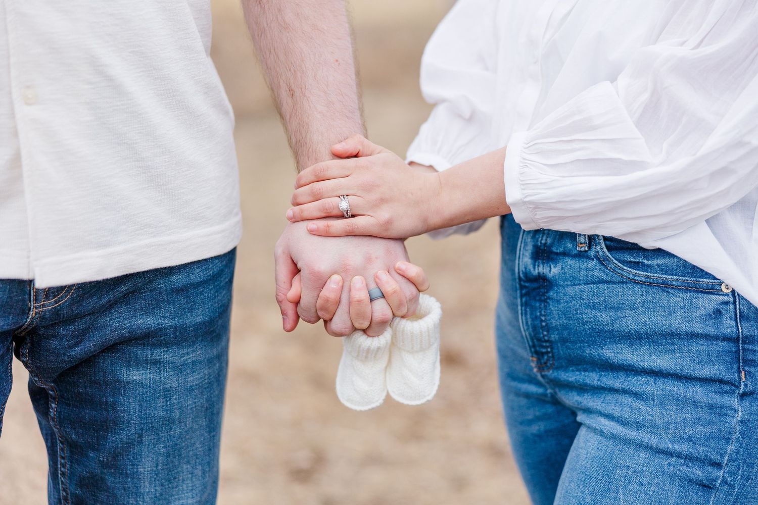 Baby booties held by couple during pregnancy announcement photos in Cary, Illinois