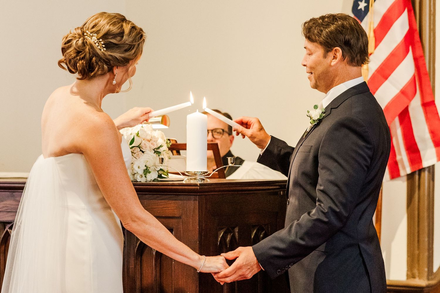 A couple exchanges rings during wedding ceremony in front of church altar.