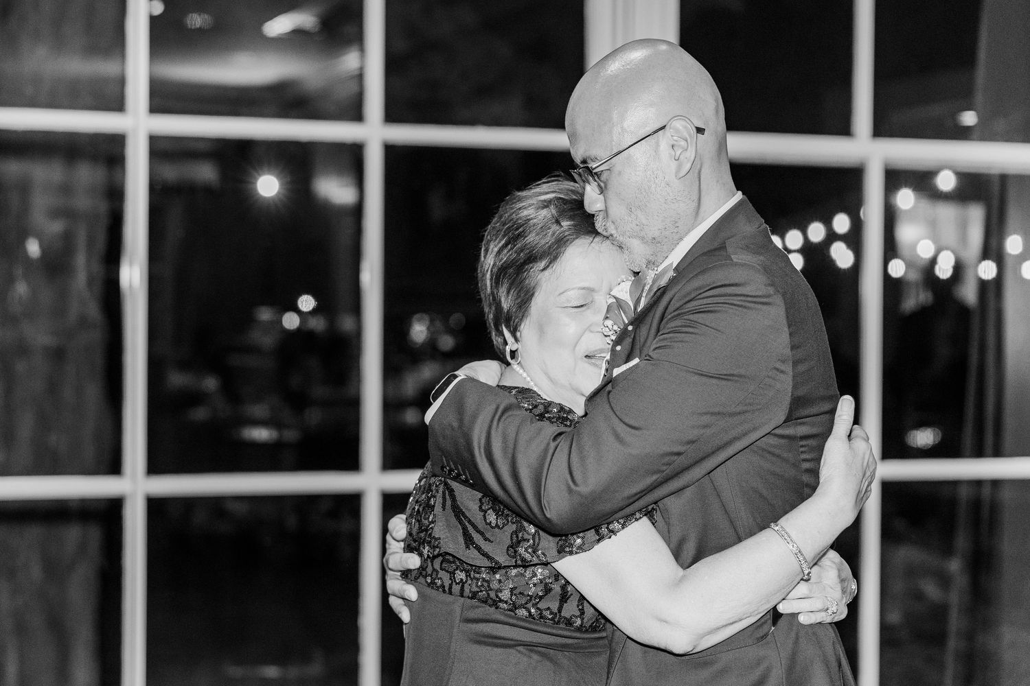 An intimate black and white photo of a couple sharing a dance at an evening reception.