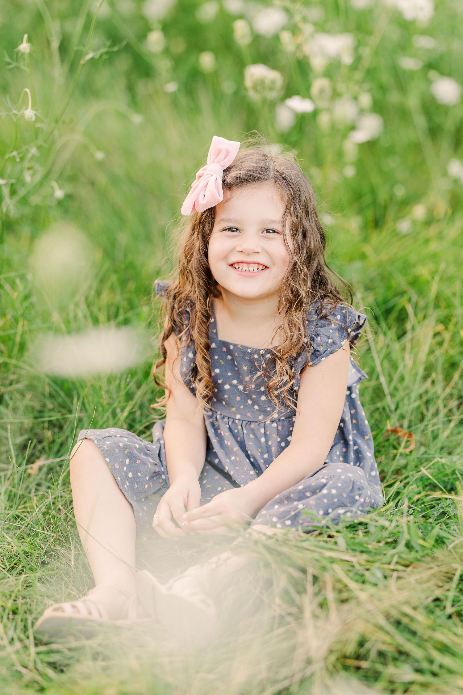 A delightful moment captured in a flower-filled meadow with soft golden lighting.