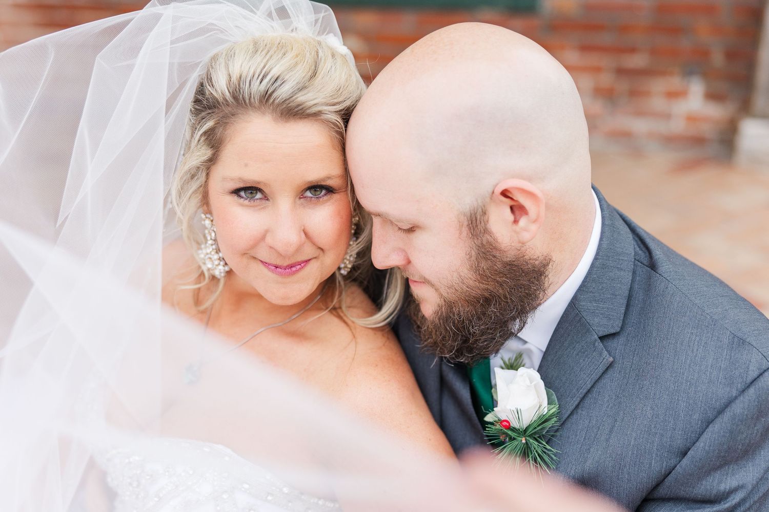 Close-up wedding portrait showing tender moment against soft background.