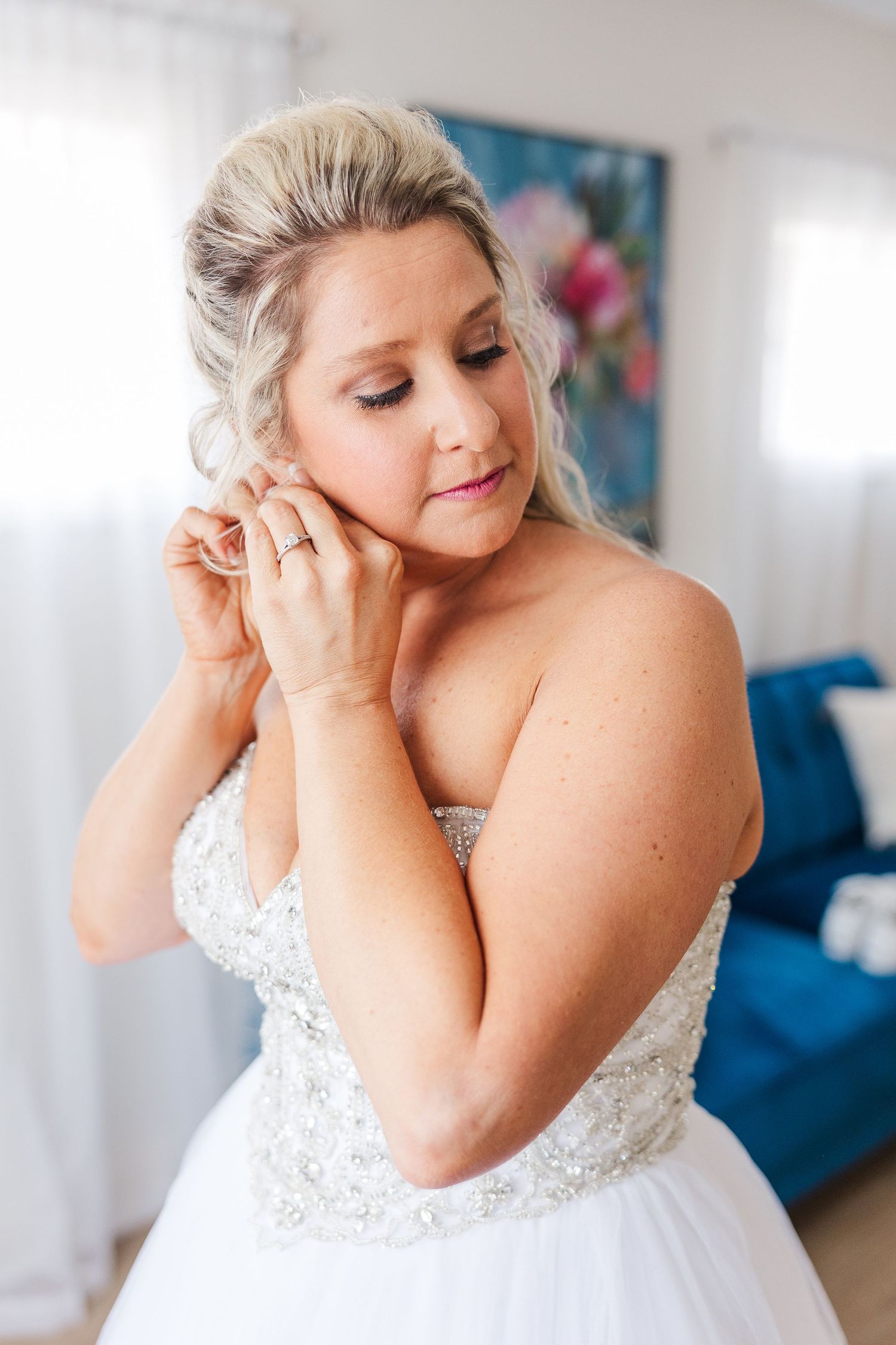Close-up shot of elegant bridal jewelry and wedding dress details in natural light.