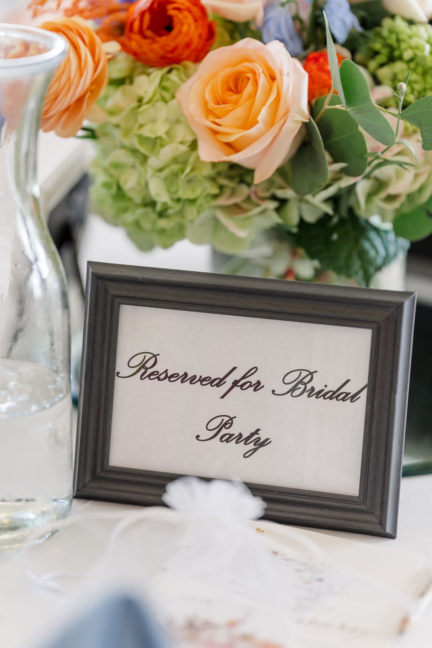 Orange rose centerpiece with reserved for bridal party sign