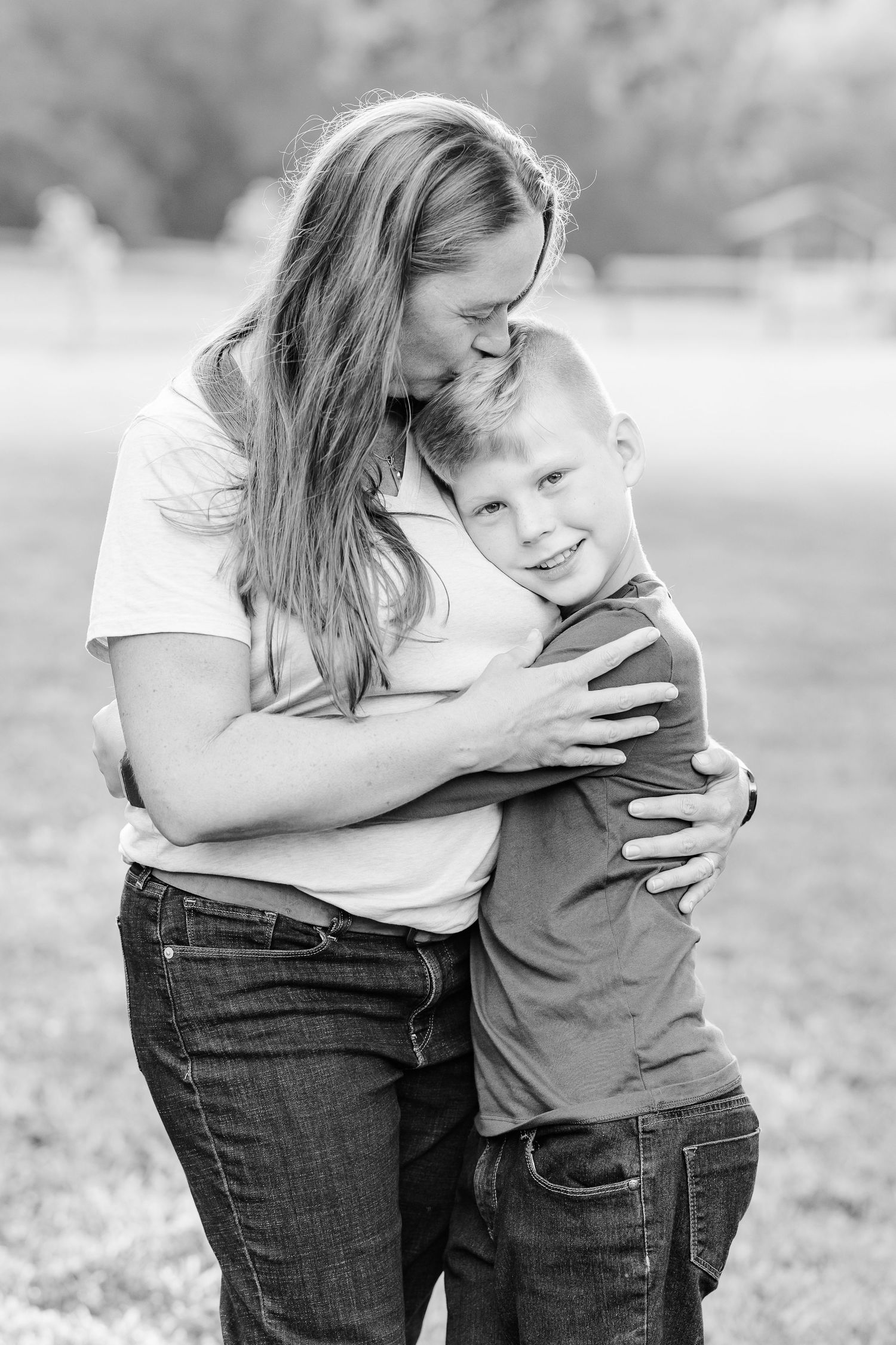 Mother hugging her son in a black and white portrait.