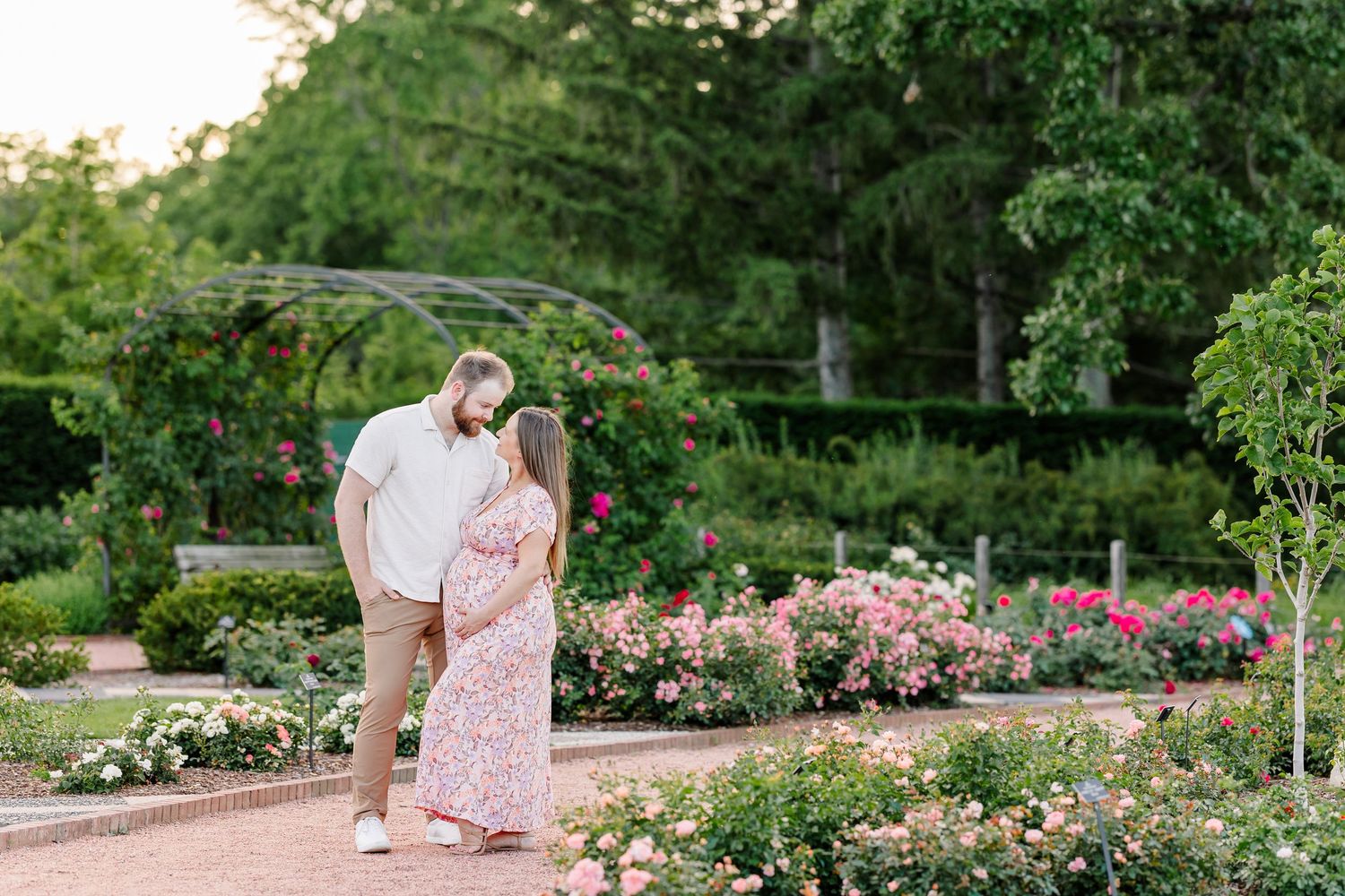 Romantic garden maternity portrait of expecting parents surrounded by flowers at Cantigny Park in Wheaton Illinois