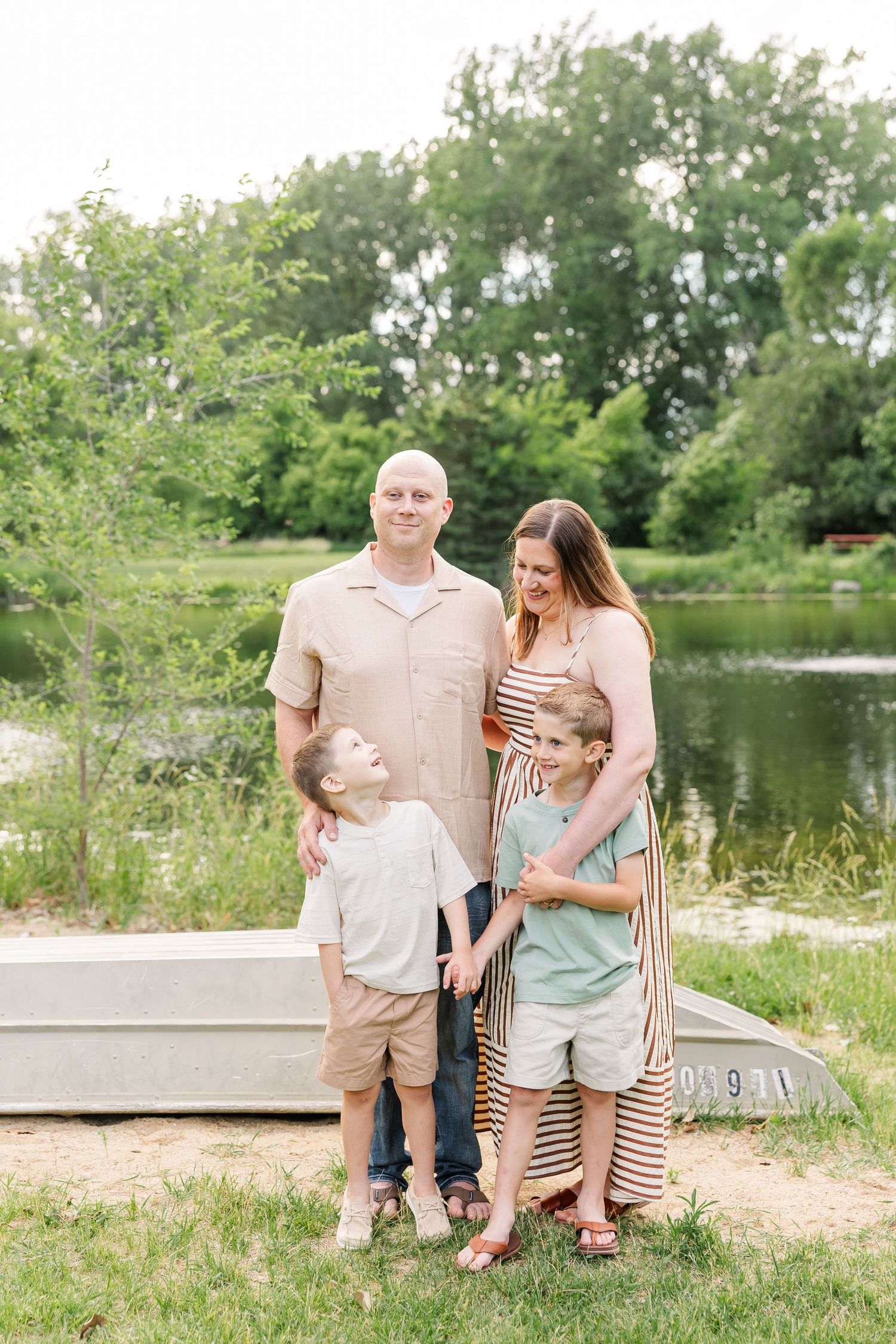 Young boy hugging his parents during a sweet family photo session by the lake in Crystal Lake, Illinois.