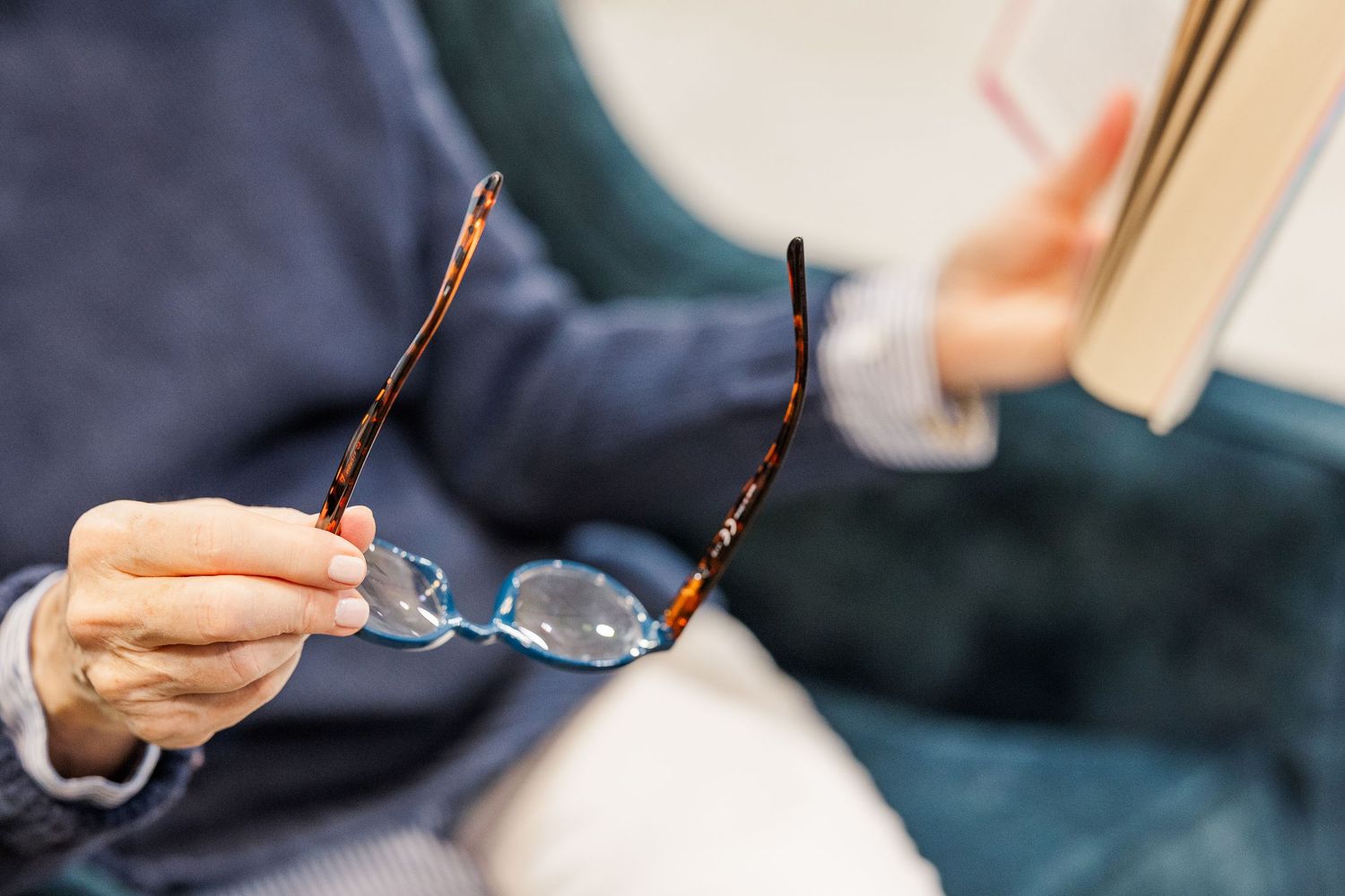 Beacon Hill senior living branding photo in Lombard, Illinois featuring eyeglasses and book in reading chair