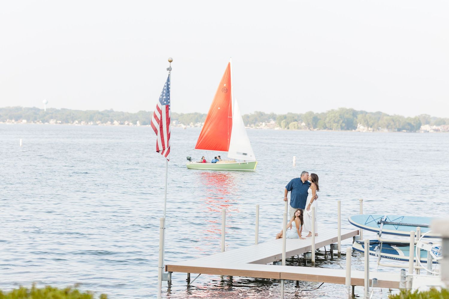 Couple on dock with sailboat during Pistakee Lake family photos in Johnsburg, Illinois