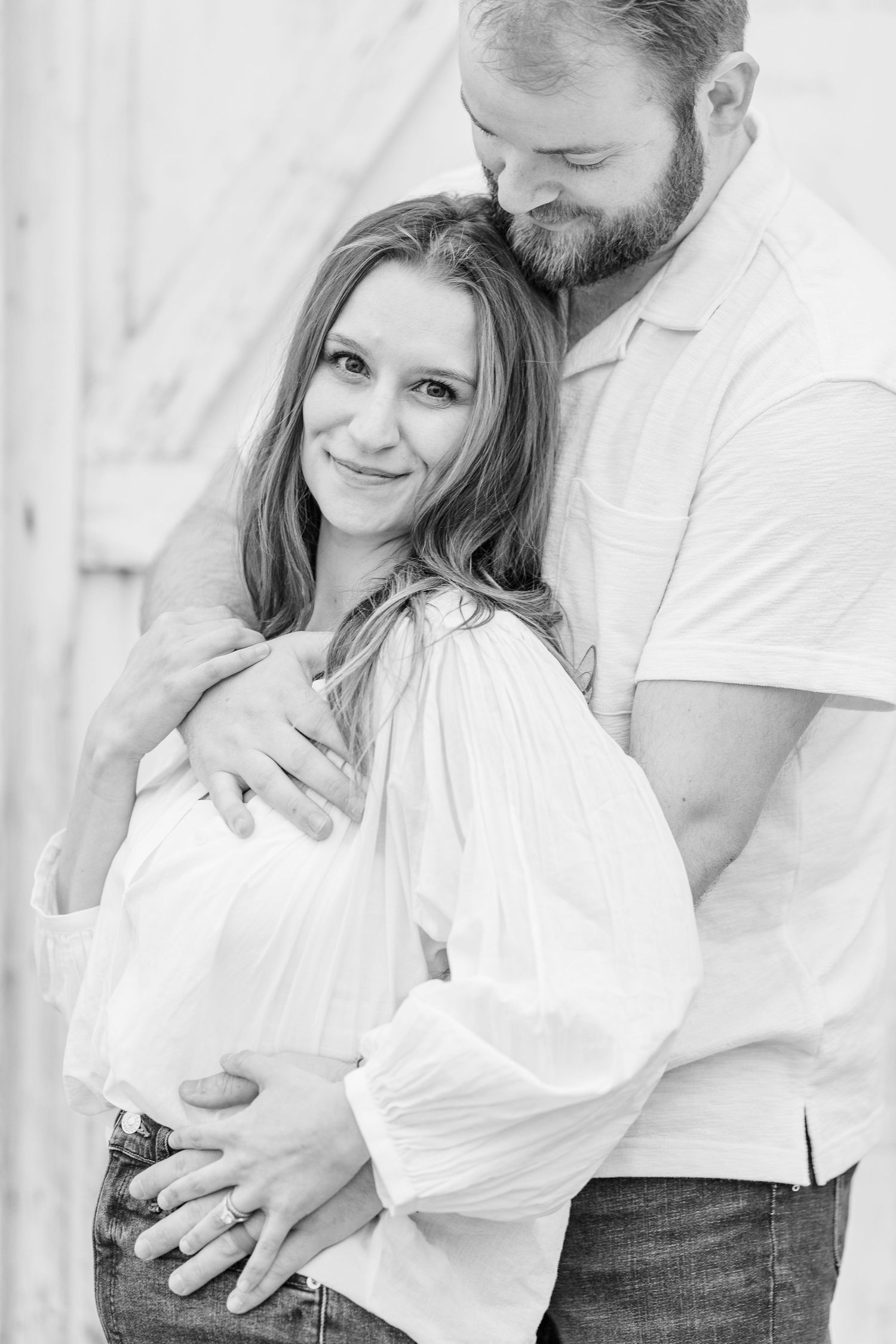 Couple embracing with baby bump during pregnancy announcement photos in Cary, Illinois