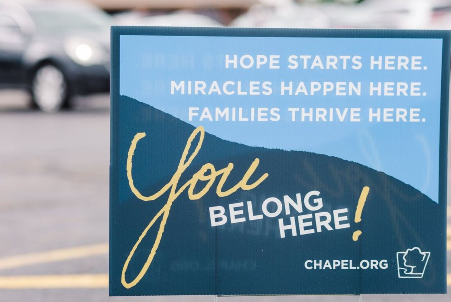 Row of blue and white church signs displaying inspirational messages about hope and belonging.
