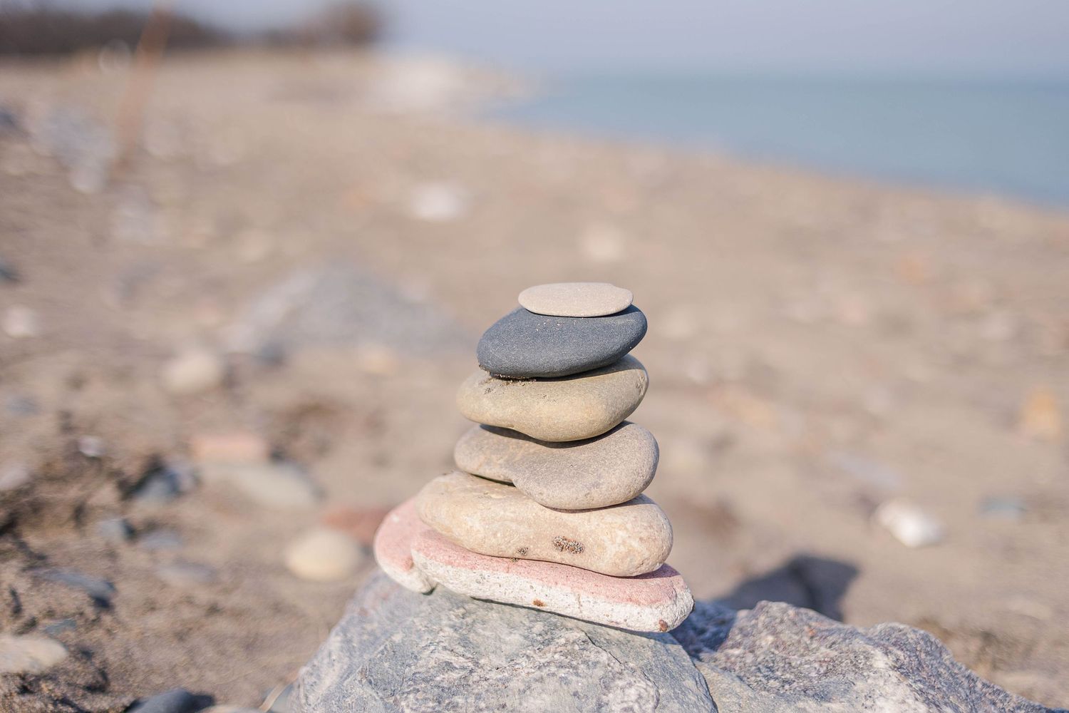 Carefully balanced cairn of smooth stones on rocky beach.