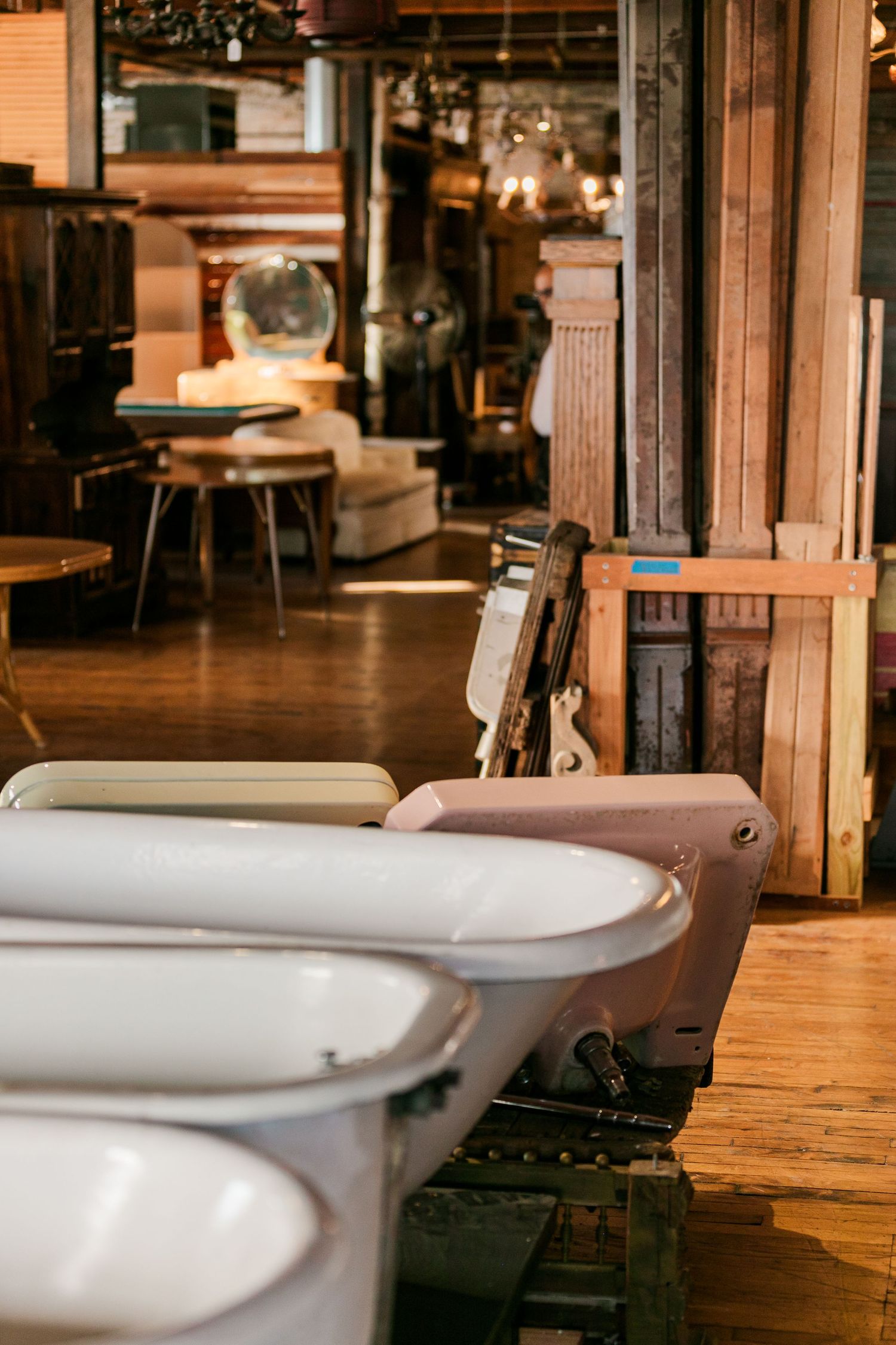 Row of vintage plush chairs with white seats line a rustic restaurant interior with warm lighting.