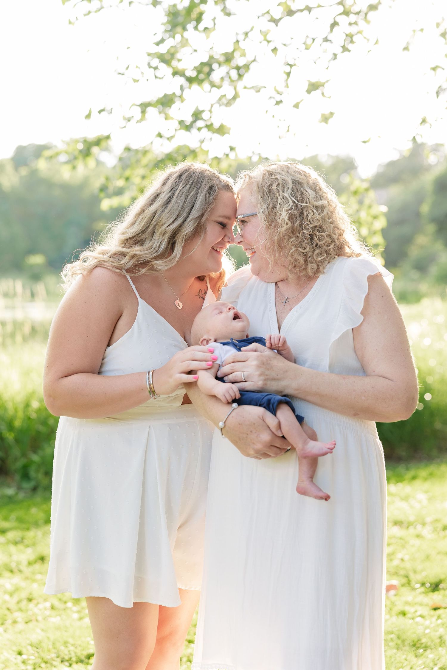 Mother and grandmother kissing a baby boy during a sweet extended family photo session in Crystal Lake, Illinois