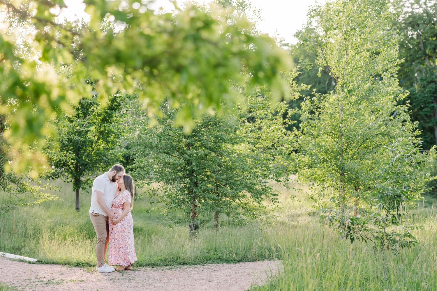 Expecting parents walking on a garden path during a summer Cantigny maternity session in Wheaton Illinois